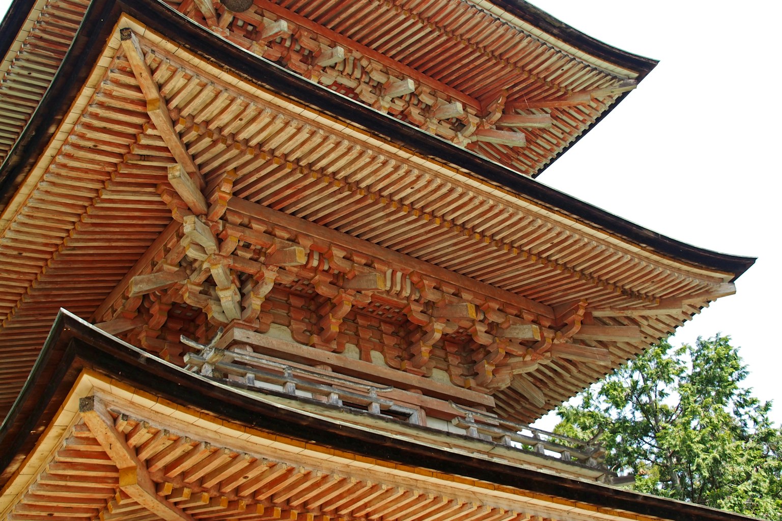 Detailed structure of a pagoda featuring wooden carvings and layered roofs