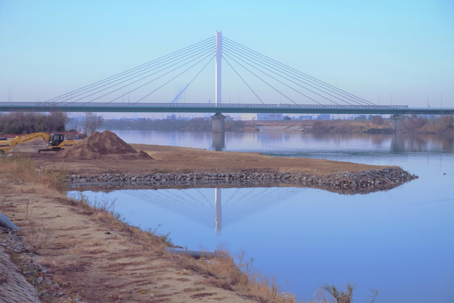 Vista escénica de un puente atirantado reflejado en agua tranquila