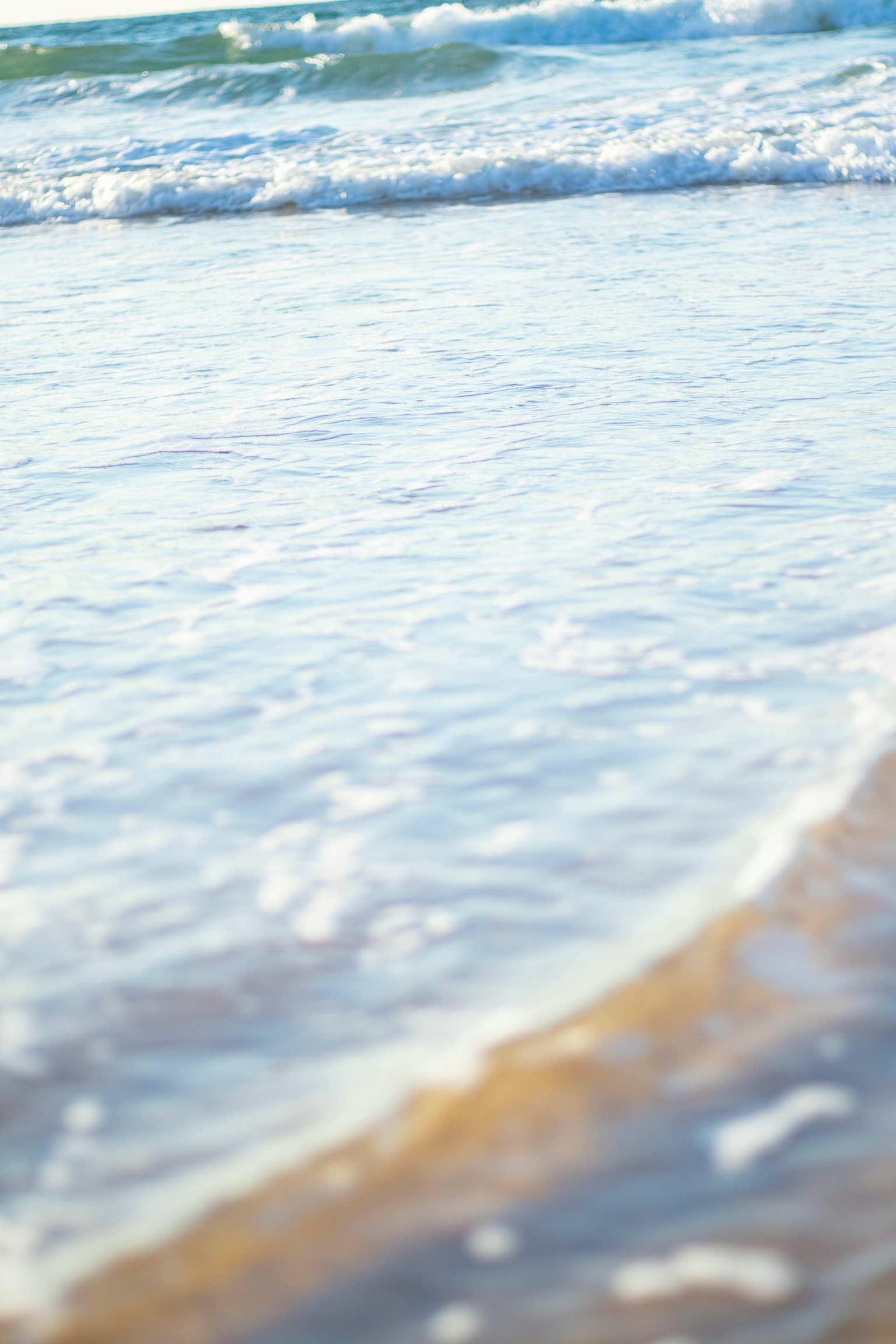 Escena de playa tranquila con olas suaves que llegan a la orilla
