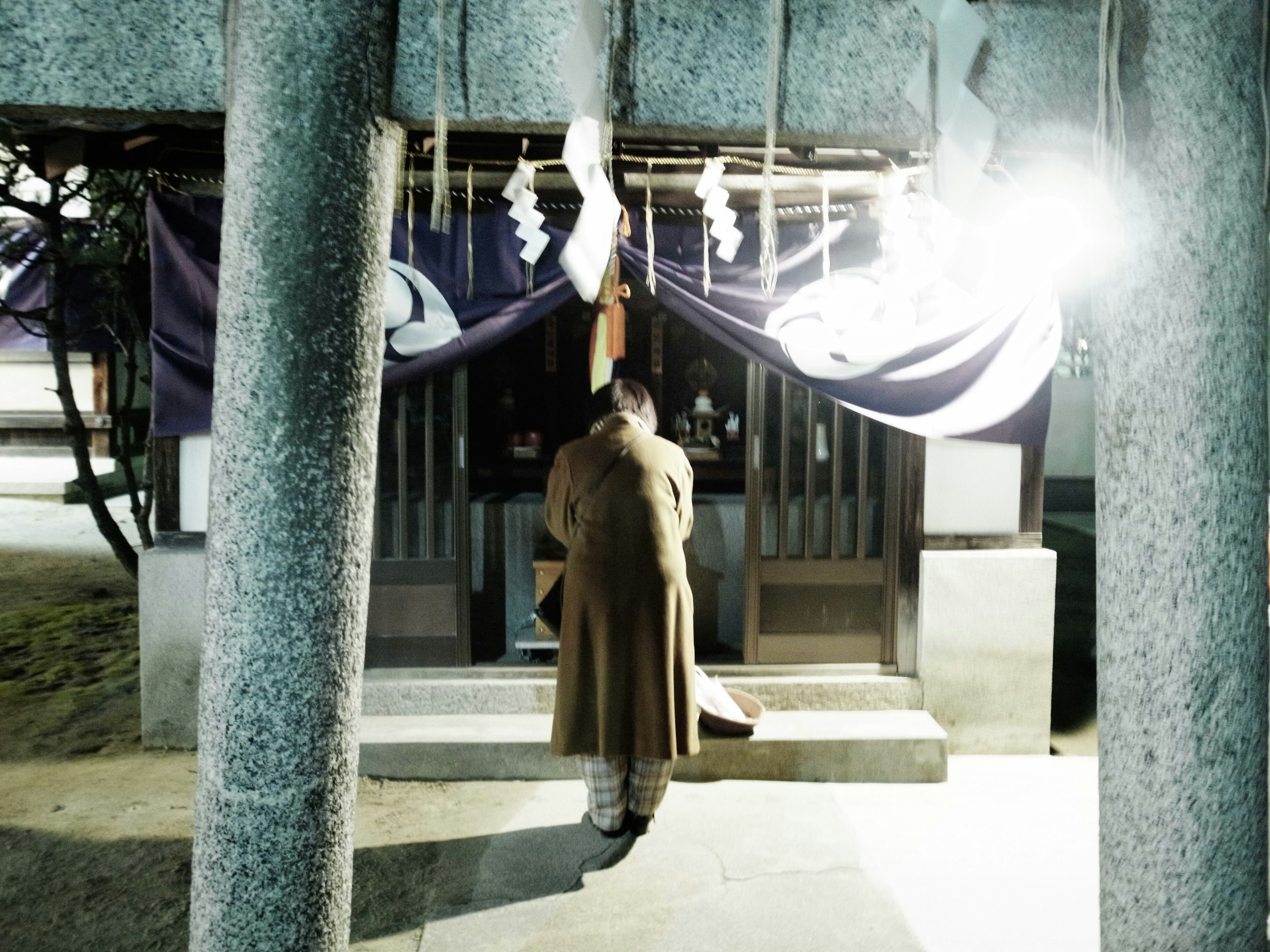 outdoor walkway with hanging clothes seen between stone pillars