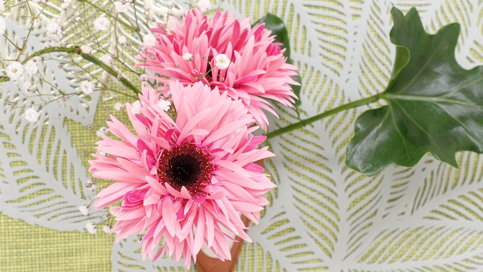 Hermoso arreglo con flores rosas y hojas verdes