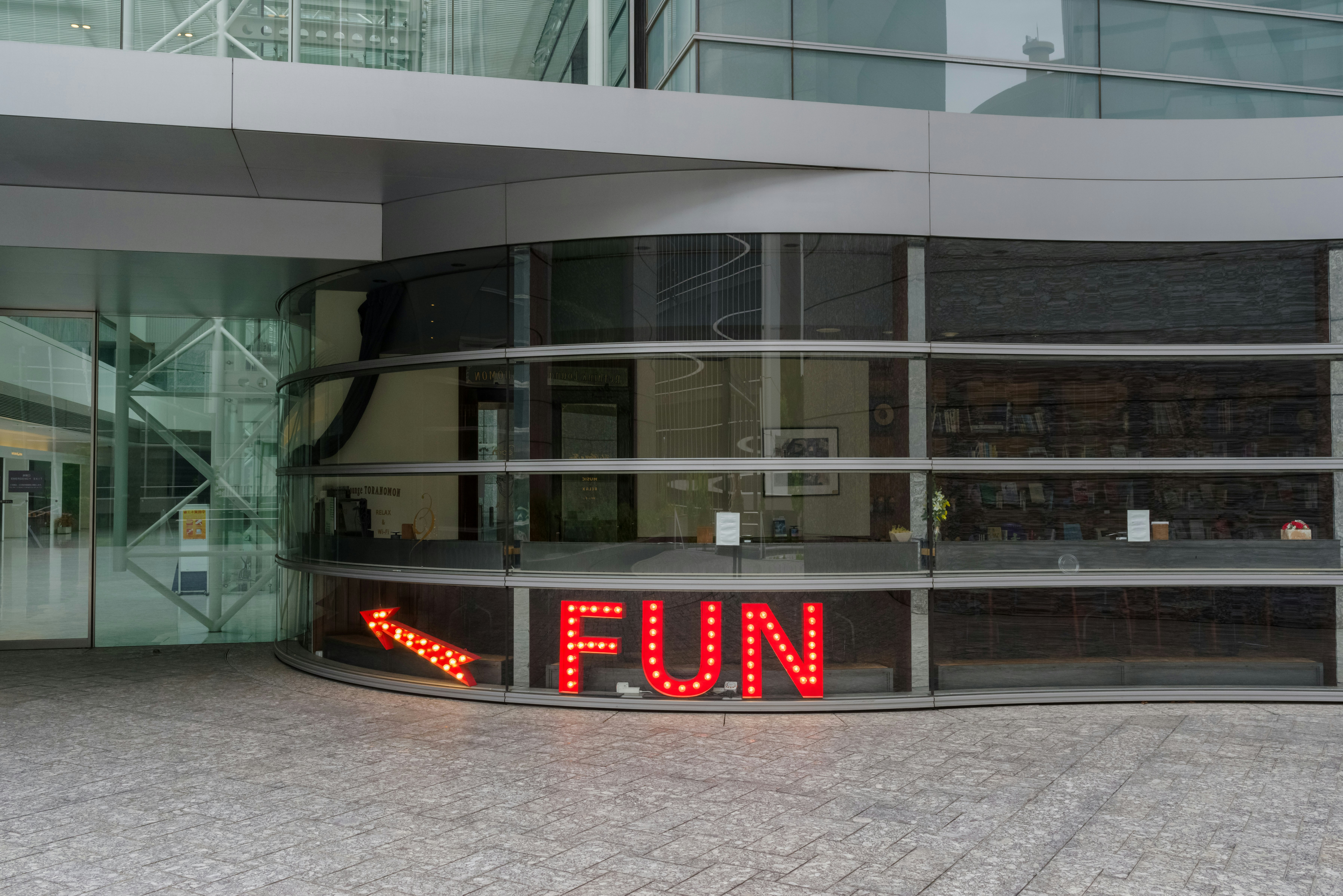 neon “FUN” sign in front of a glass building