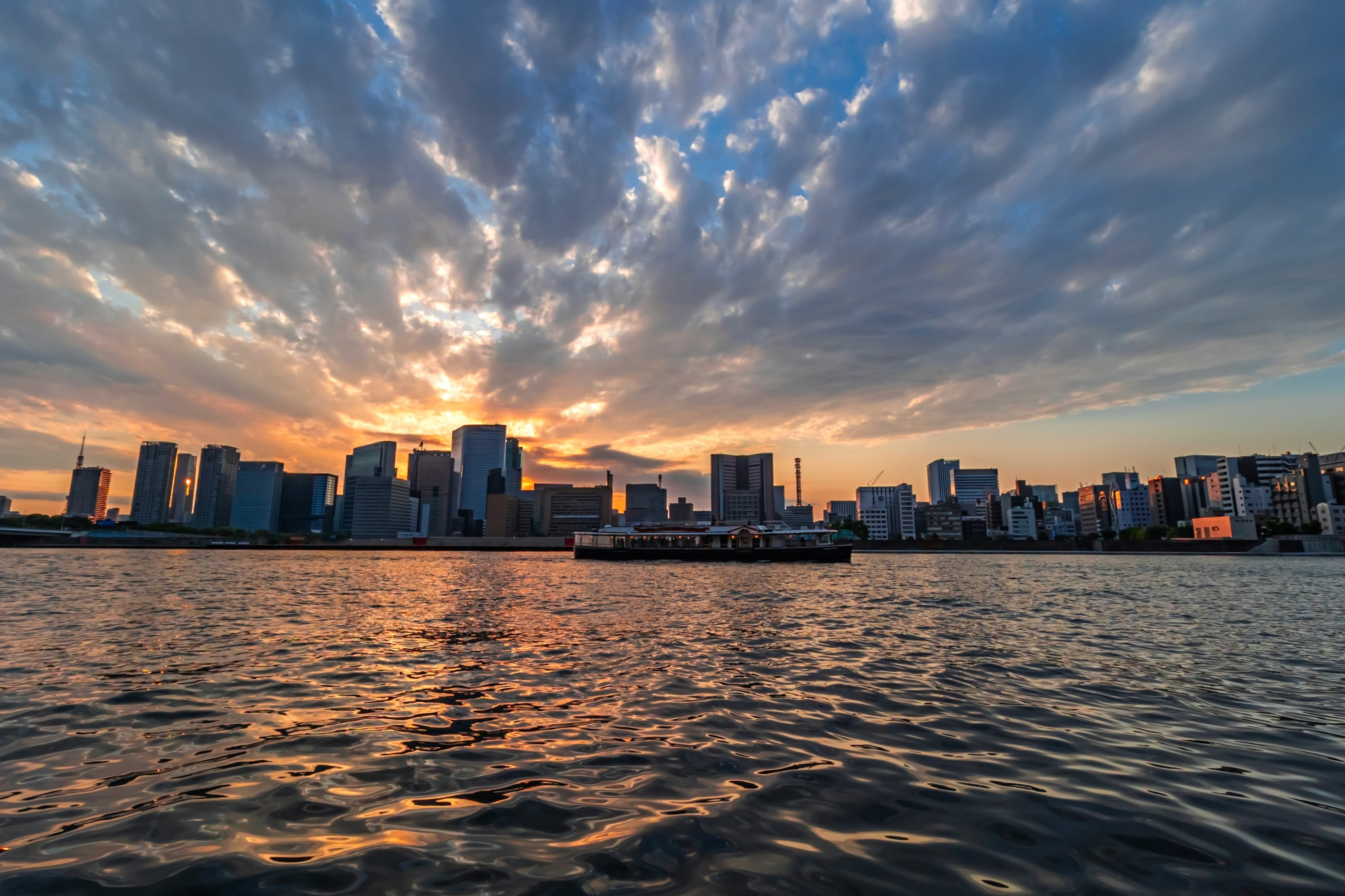 隅田川の夕景と川面に映る都心のビル群