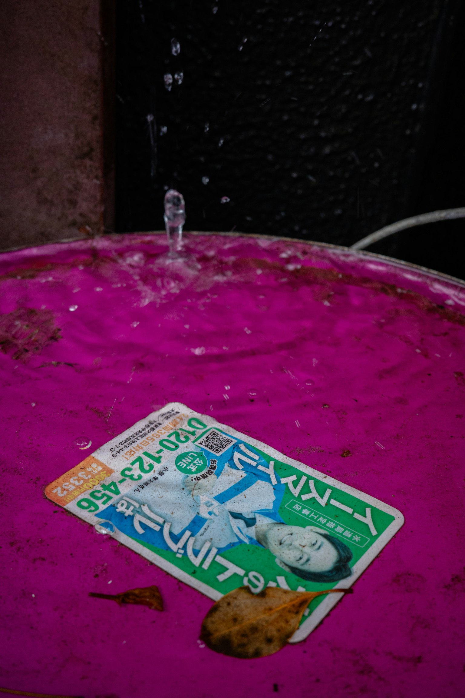 การ์ดวางอยู่บนถังสีชมพูพร้อมน้ำกระเซ็น