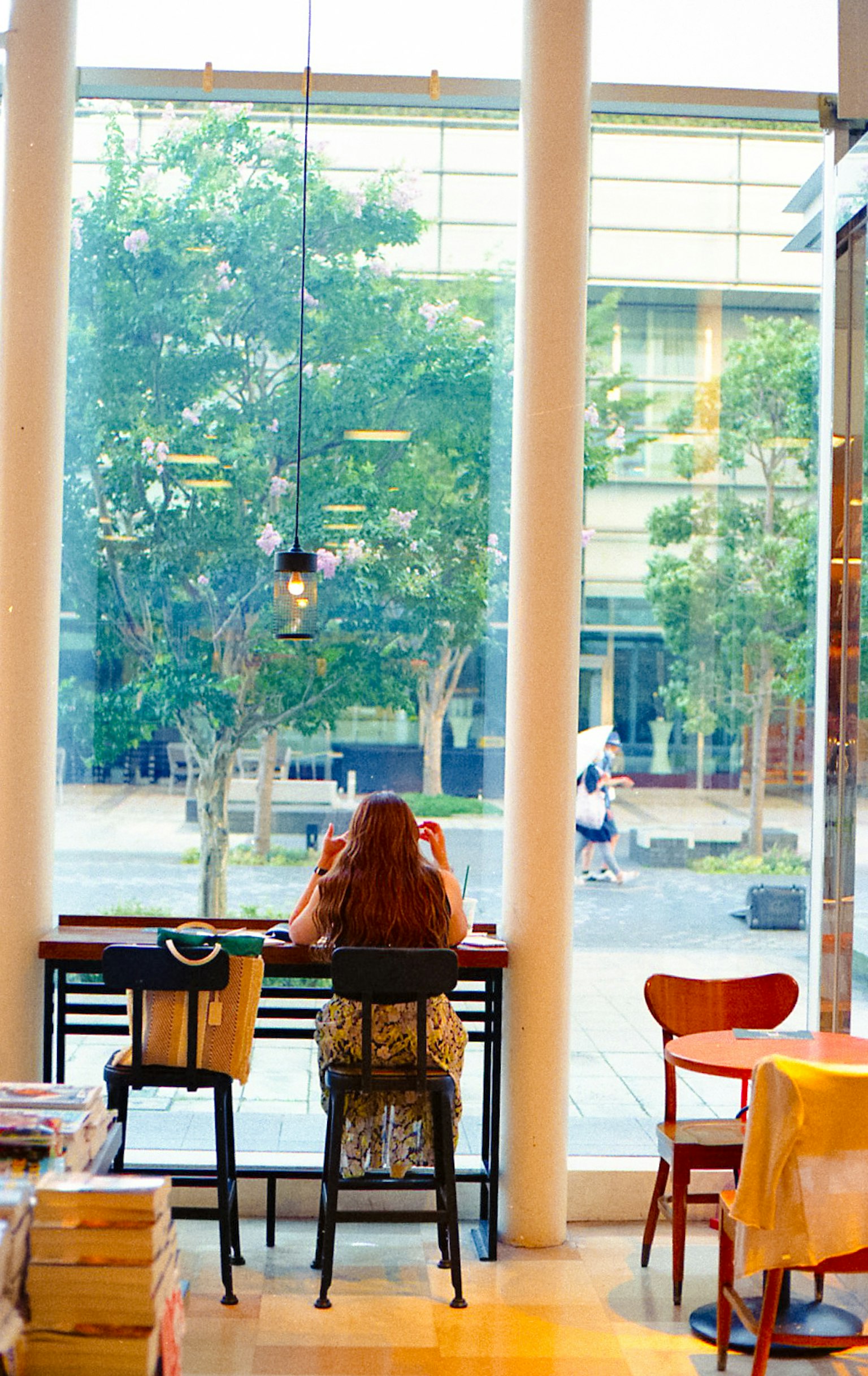 Foto di un interno di caffè con una donna seduta vicino alla finestra