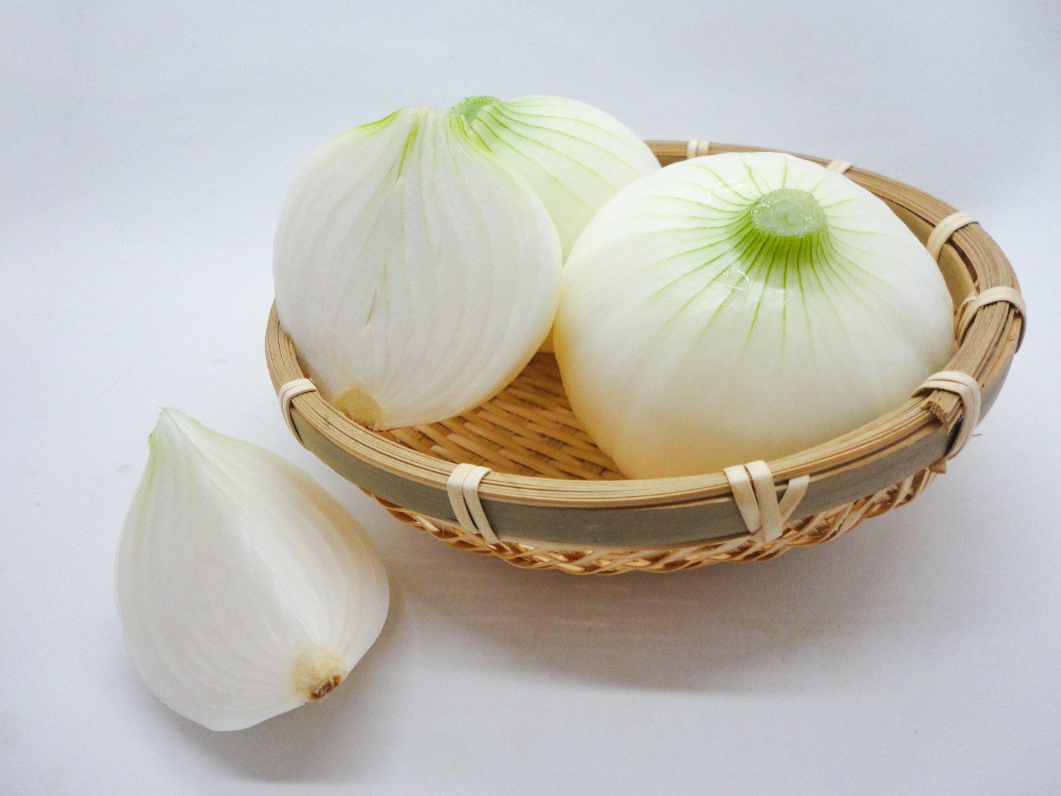 White onions are arranged in a woven basket