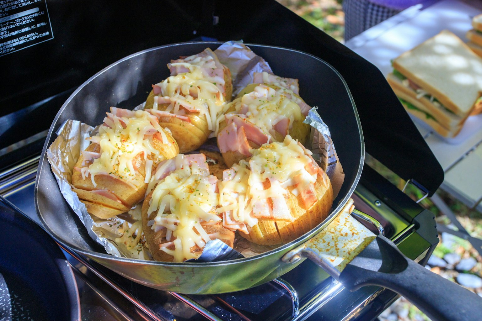 Petits pains cuits garnis de fromage et de jambon en train de cuire dans une poêle