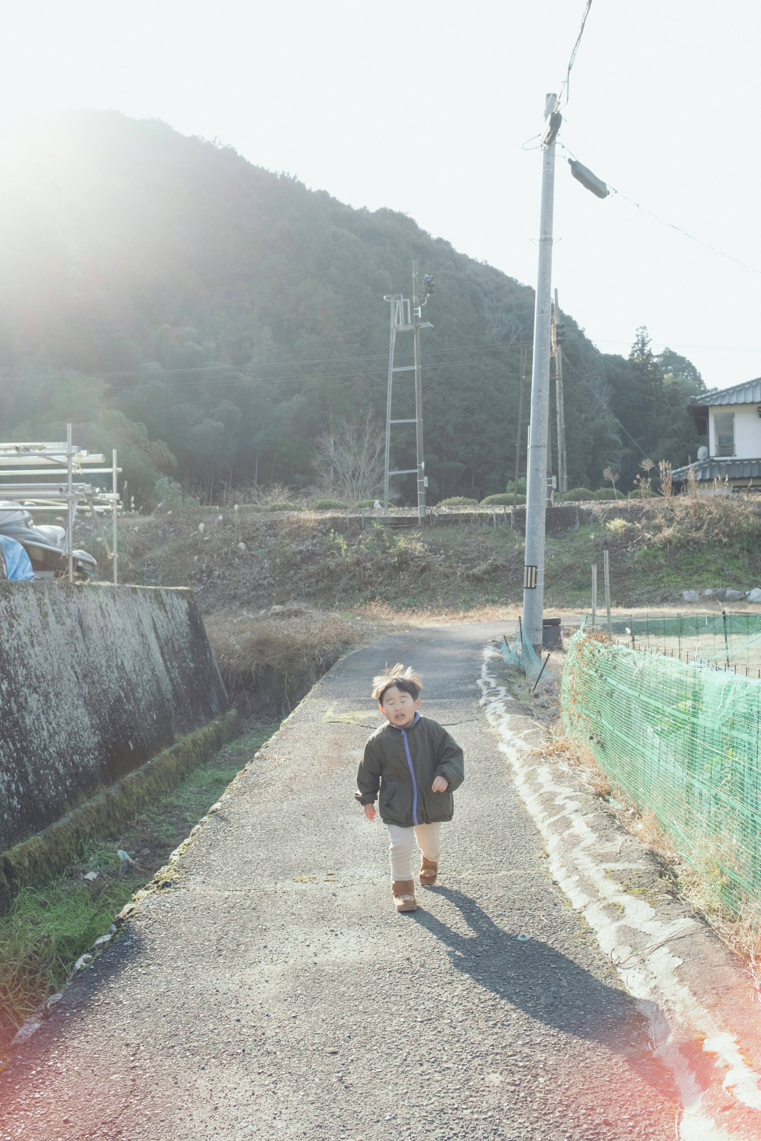 山あいの道を歩く息子
