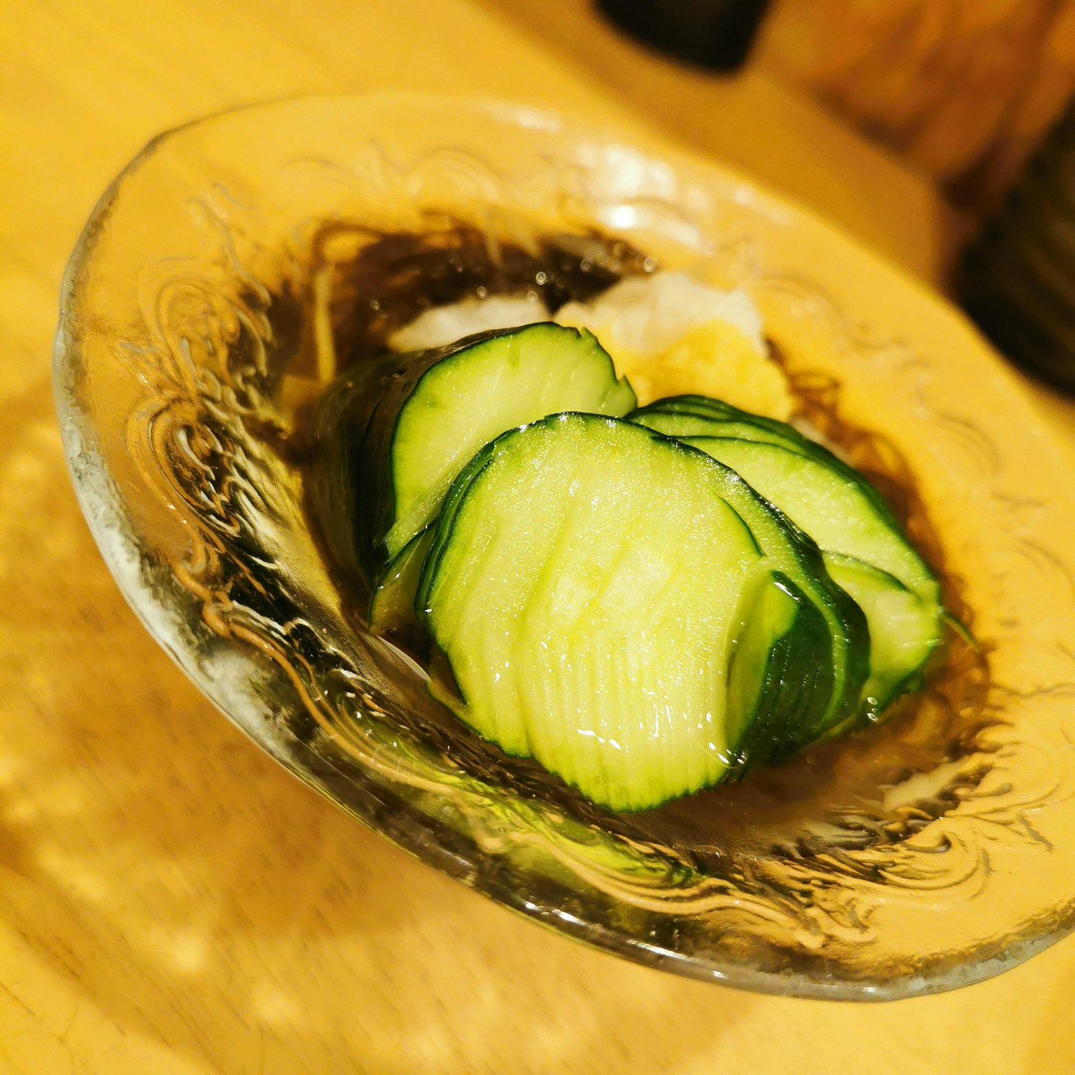 透明盘子里的日式沙拉，包含切片黄瓜和白色食材