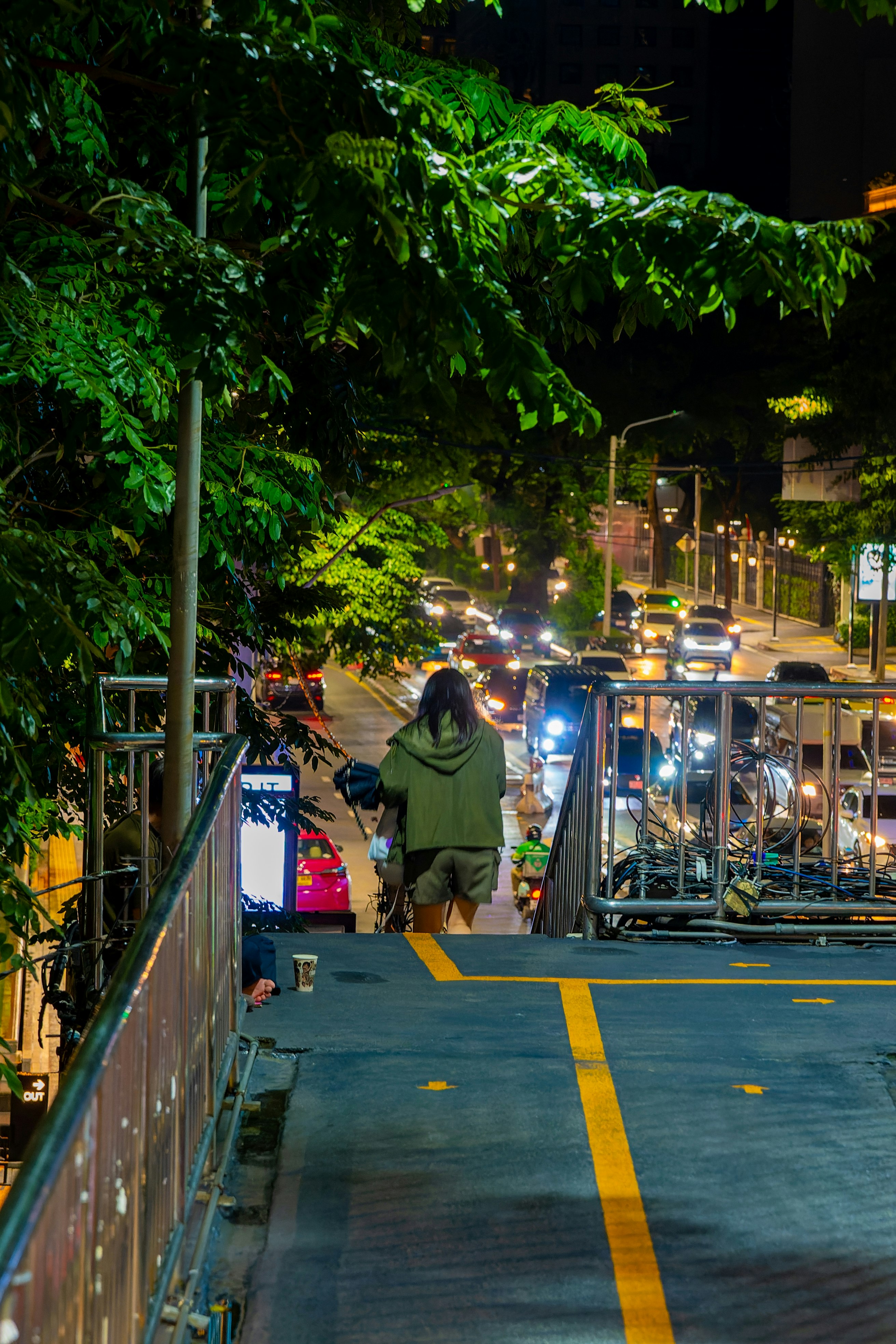 Escena nocturna en Bangkok con bicicletas y motocicletas alineadas a lo largo del callejón