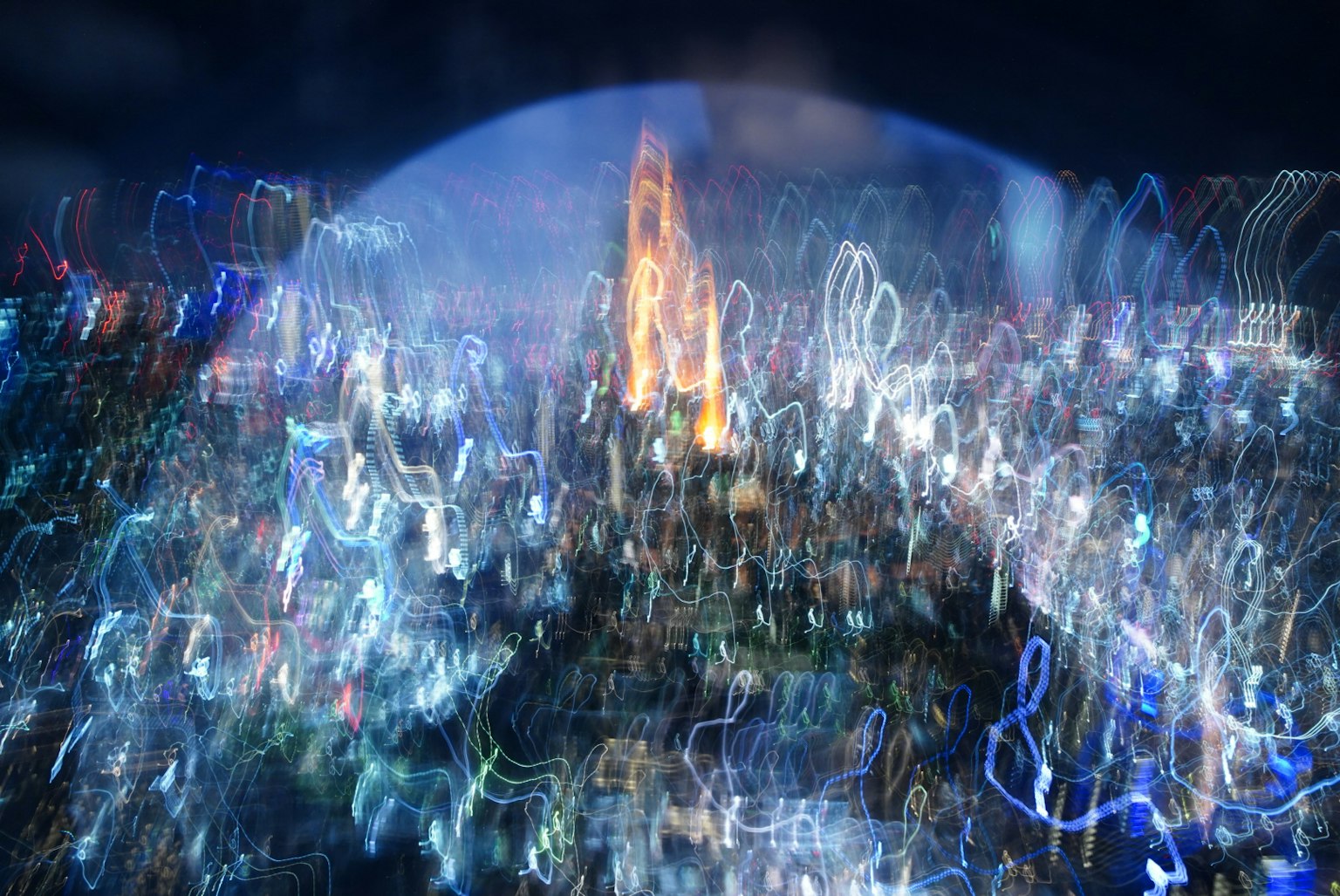 模糊的夜景中明亮建筑轮廓和五彩缤纷的光轨