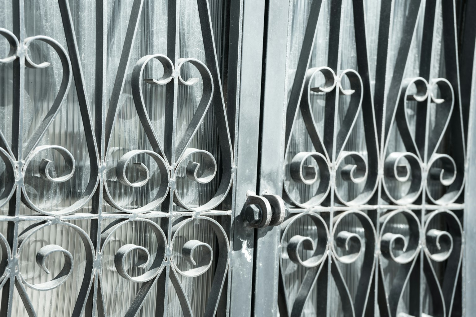 Close-up of a decorative iron gate featuring intricate patterns and curves