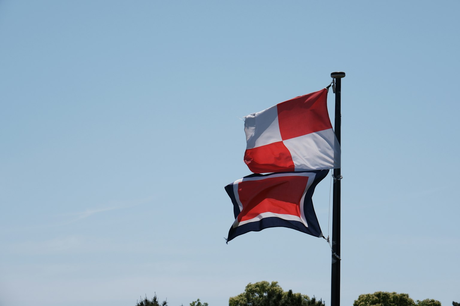 Drapeau de la République dominicaine flottant sous un ciel bleu clair