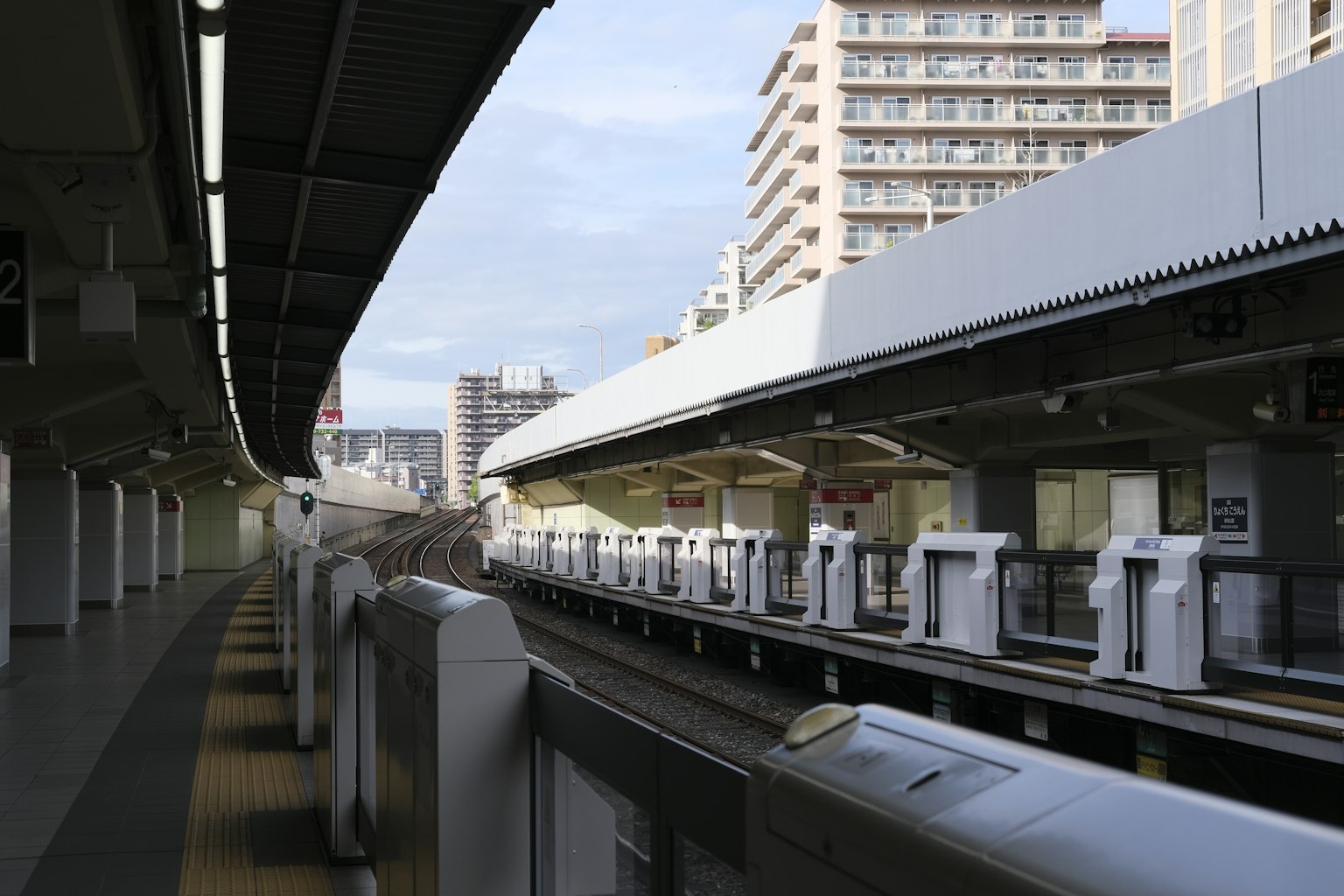 ทิวทัศน์เมืองแสดงแพลตฟอร์มรถไฟพร้อมอุโมงค์รถไฟและอาคารสูง