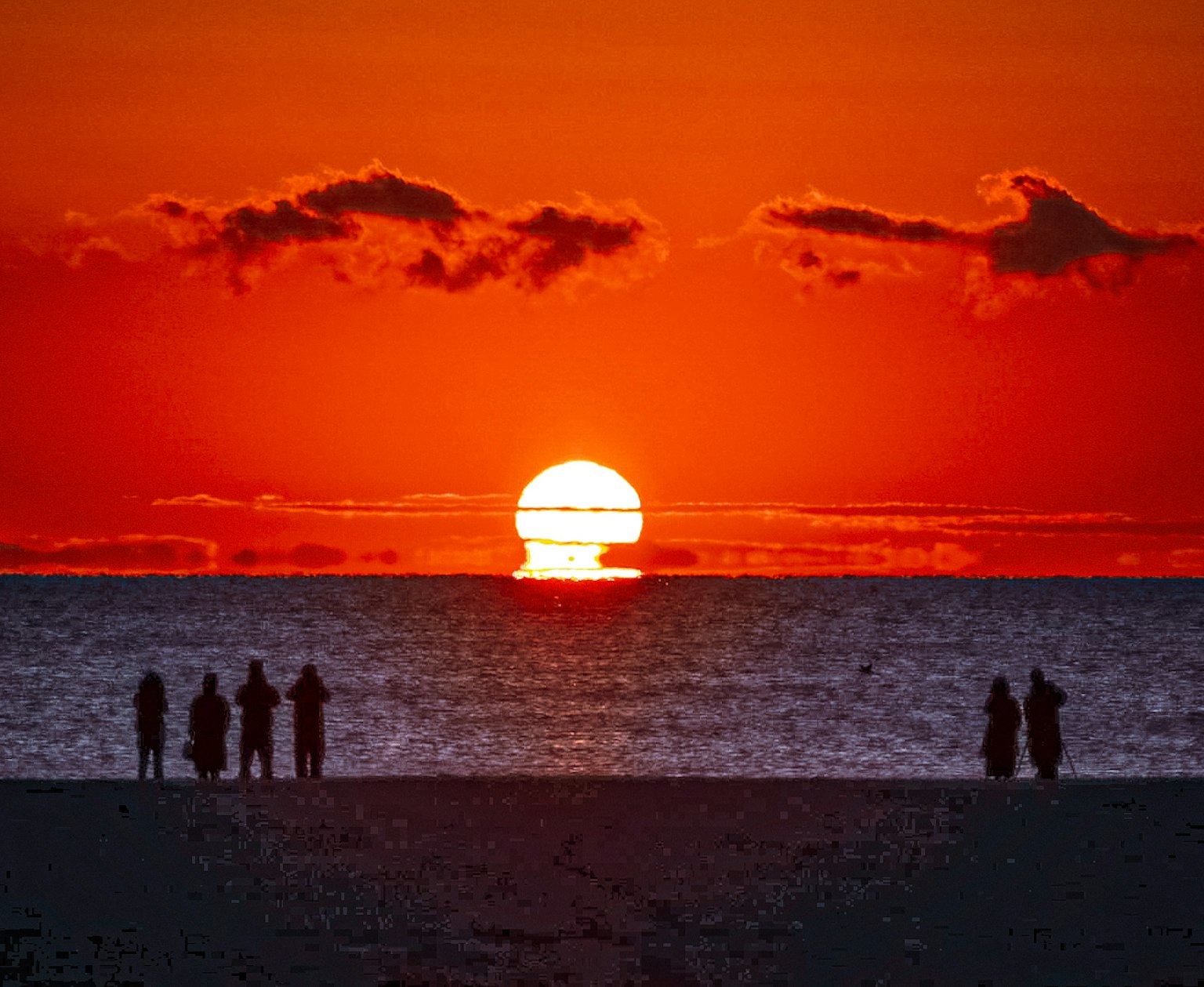 Splendido tramonto sull'oceano con figure in silhouette