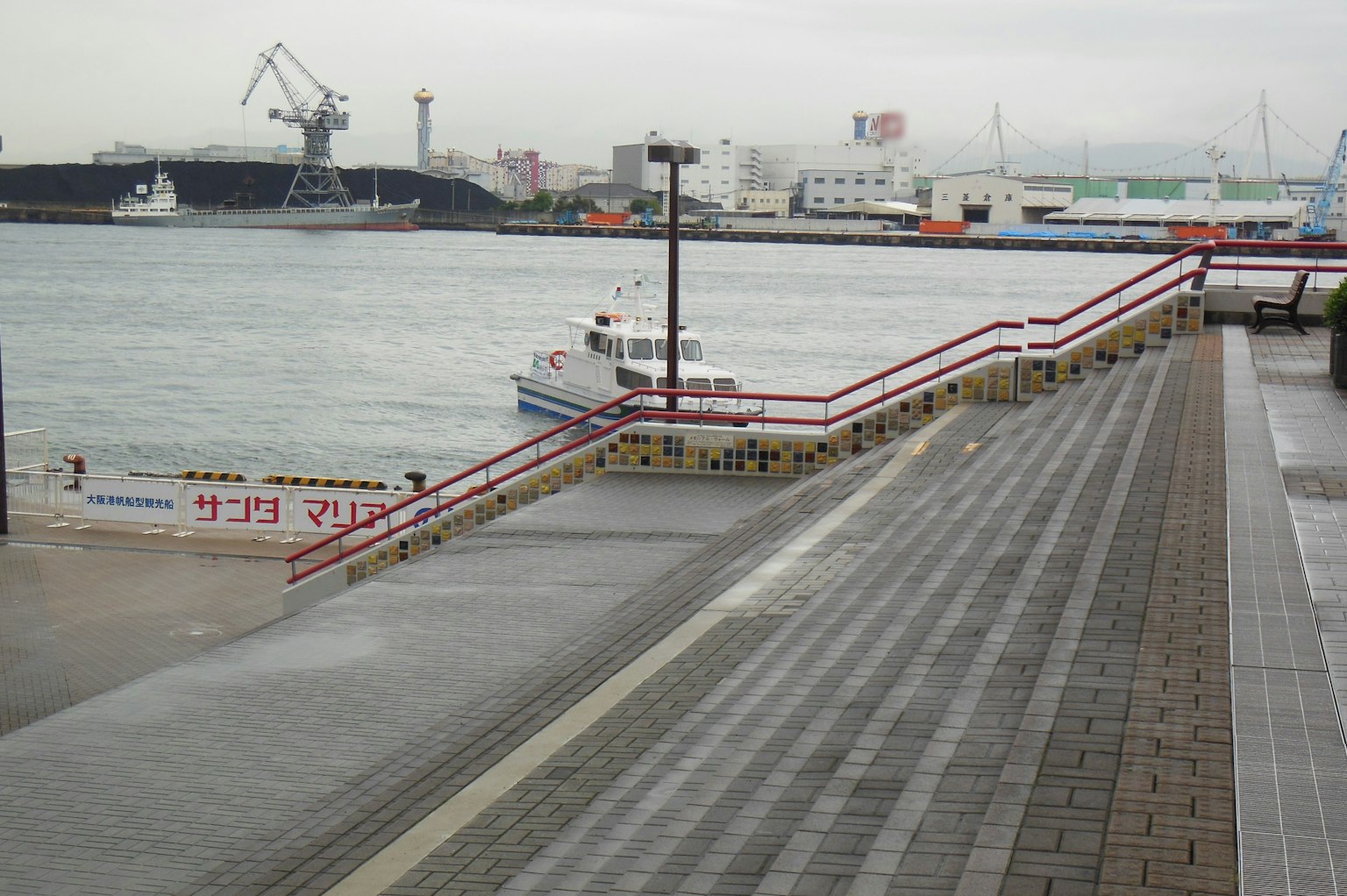 Uferpromenade mit einem Boot und Blick auf den Hafen