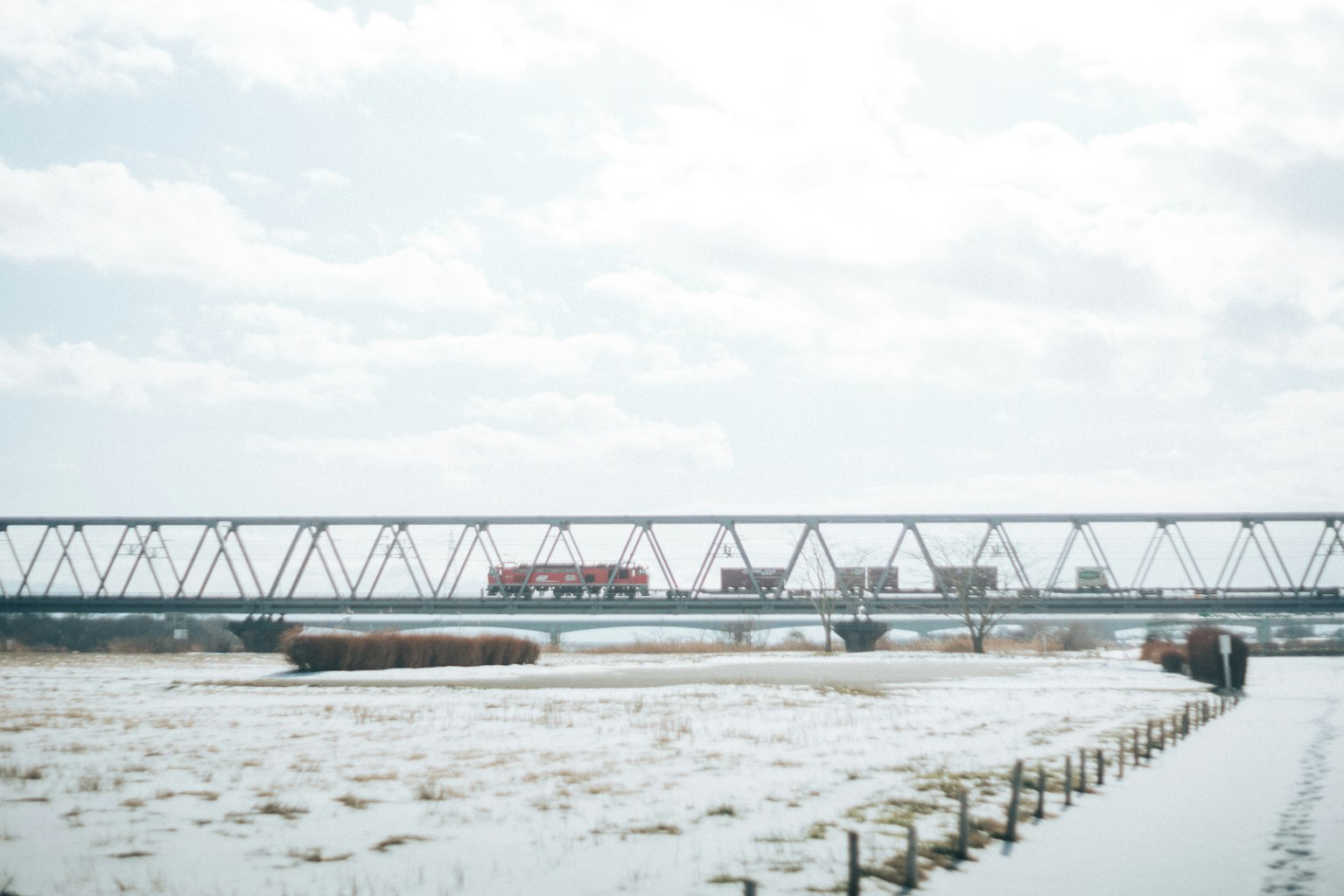 Train traversant un paysage enneigé sous un ciel nuageux