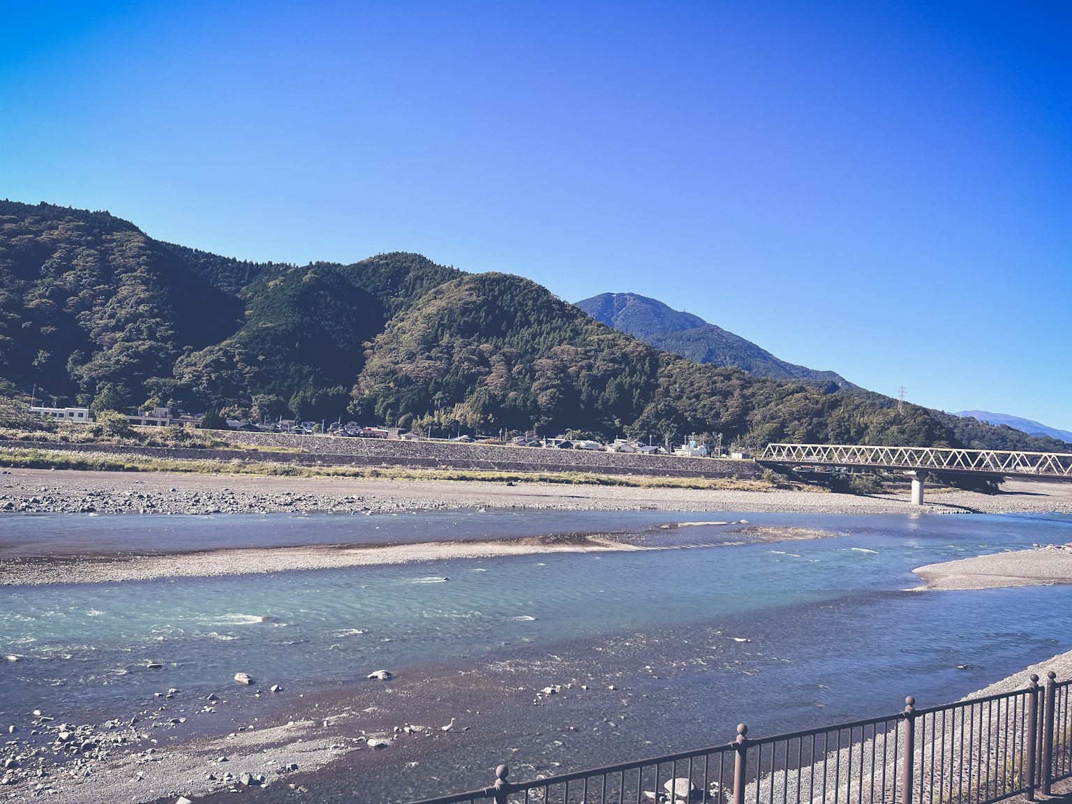 Landschaft mit einem ruhigen Fluss und Bergen im Hintergrund
