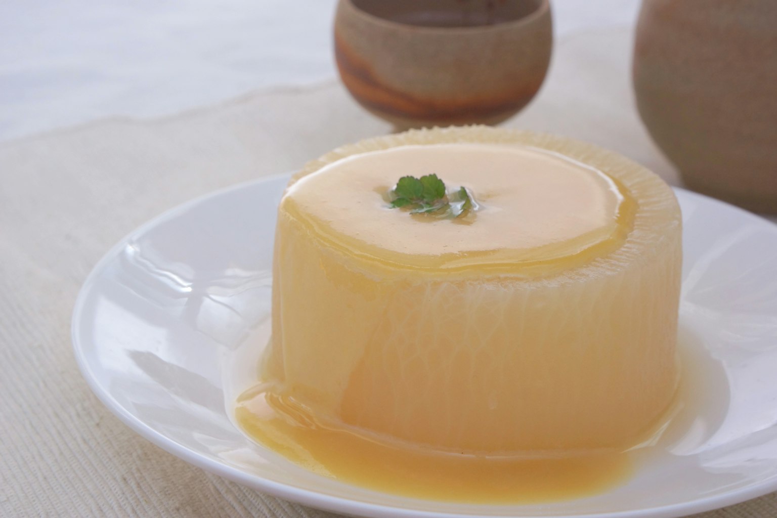 Ein cremiger Pudding auf einem Teller garniert mit einem Minzblatt