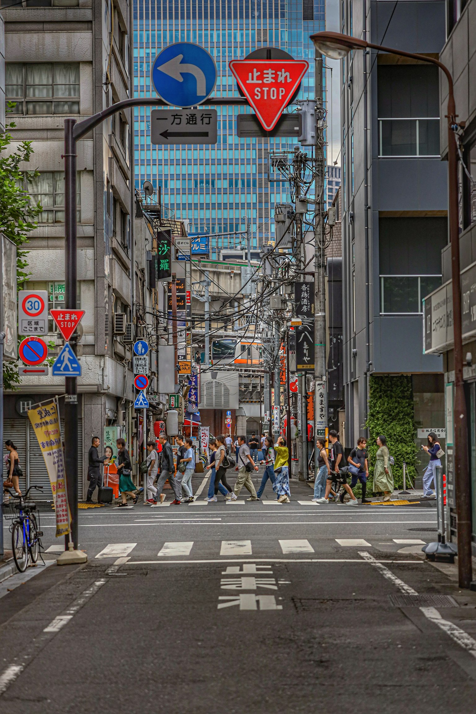 แยกในเมืองที่มีผู้คนข้ามถนนป้ายจราจรและอาคารมองเห็นได้