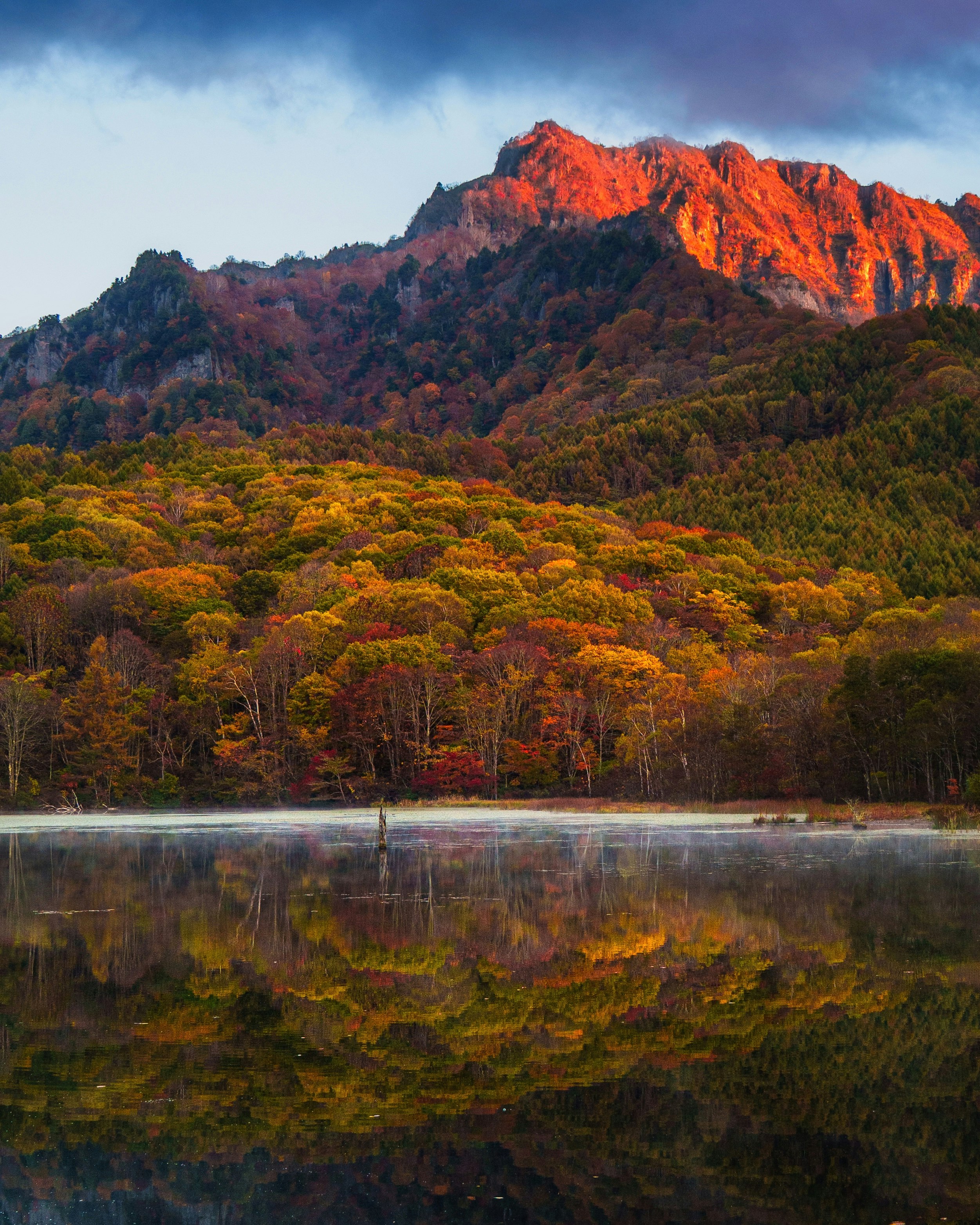 A serene mirror pond reflecting a blazing mountain