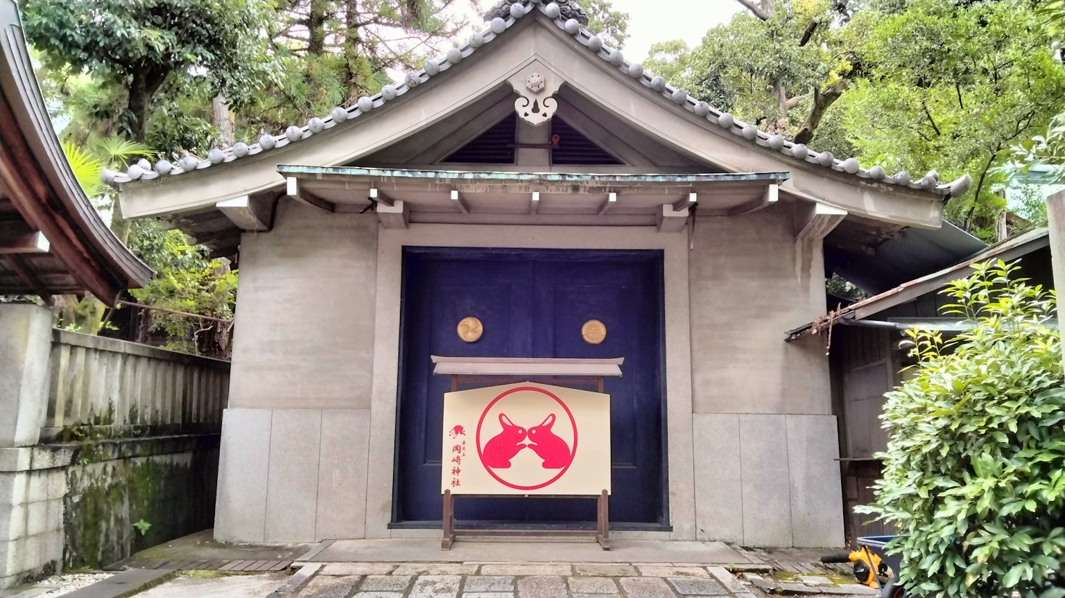 Außenansicht eines traditionellen japanischen Gebäudes mit einer blauen Tür und einem Banner mit einem roten Emblem