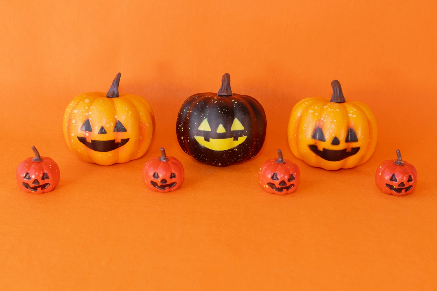 Labu Halloween berwarna-warni disusun di latar belakang oranye