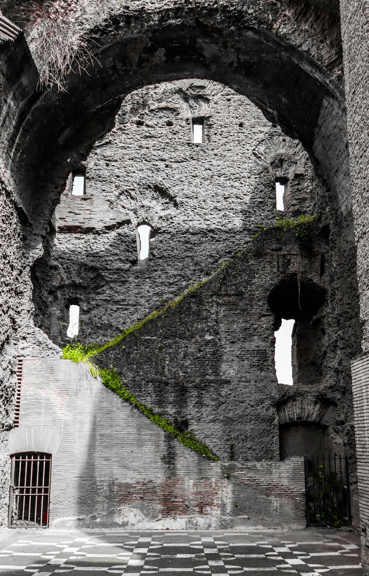 Innenraum eines alten Steinbaus grüne Pflanzen wachsen an der Wand markante Fensterformen