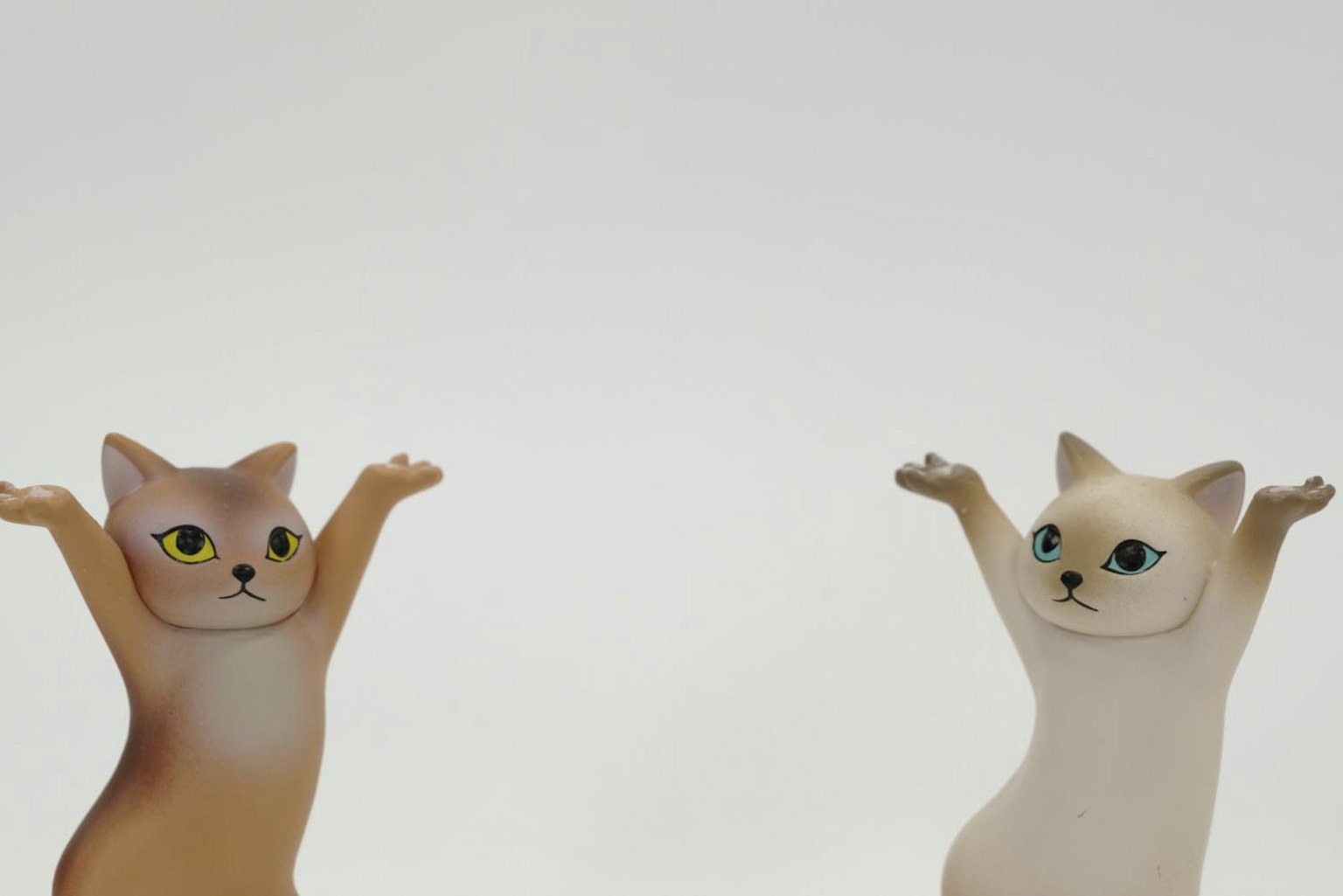Dua patung kucing dengan tangan terangkat