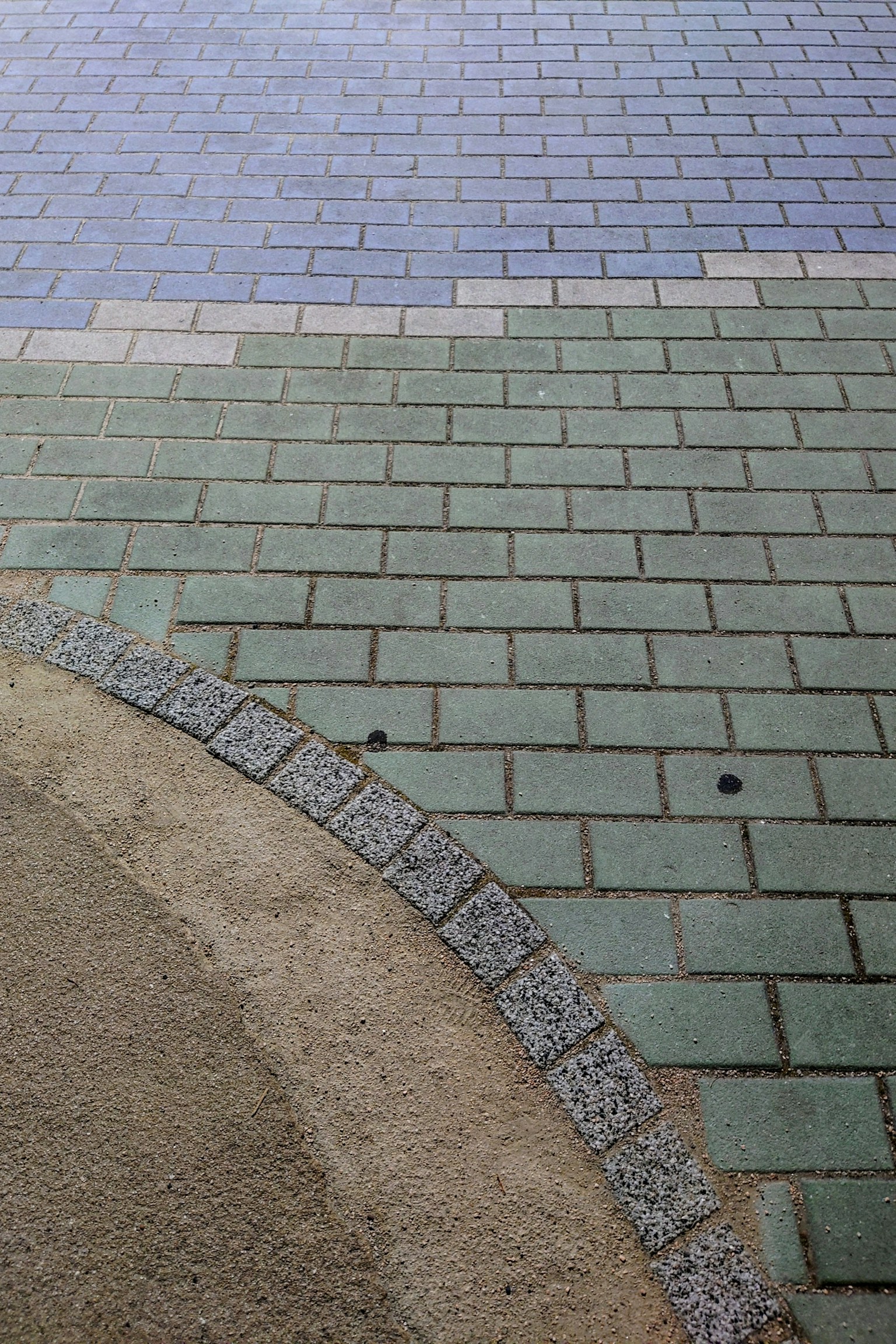Motif de carreaux verts et bleus se croisant sur le pavé