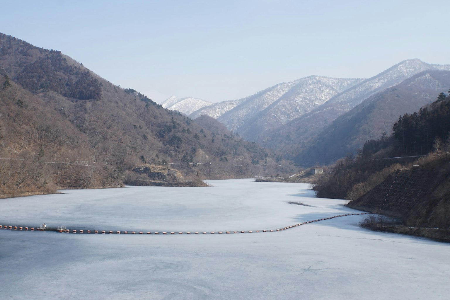 Winter landscape featuring snow-capped mountains and a frozen lake