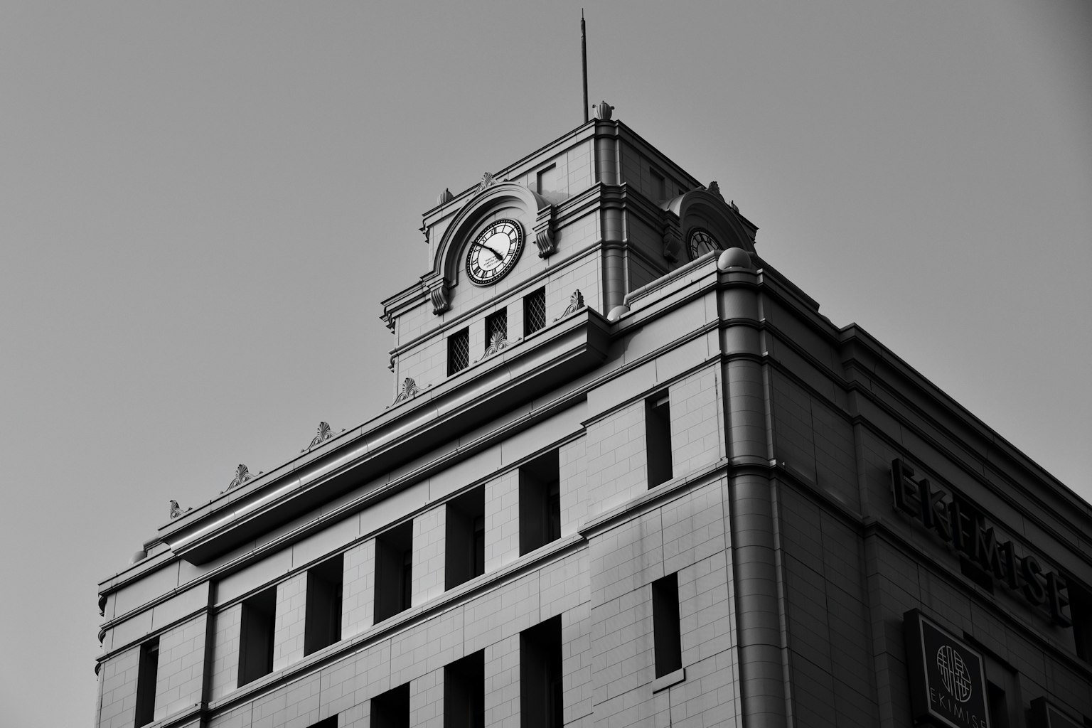 Close-up of a historic building with a clock tower in black and white