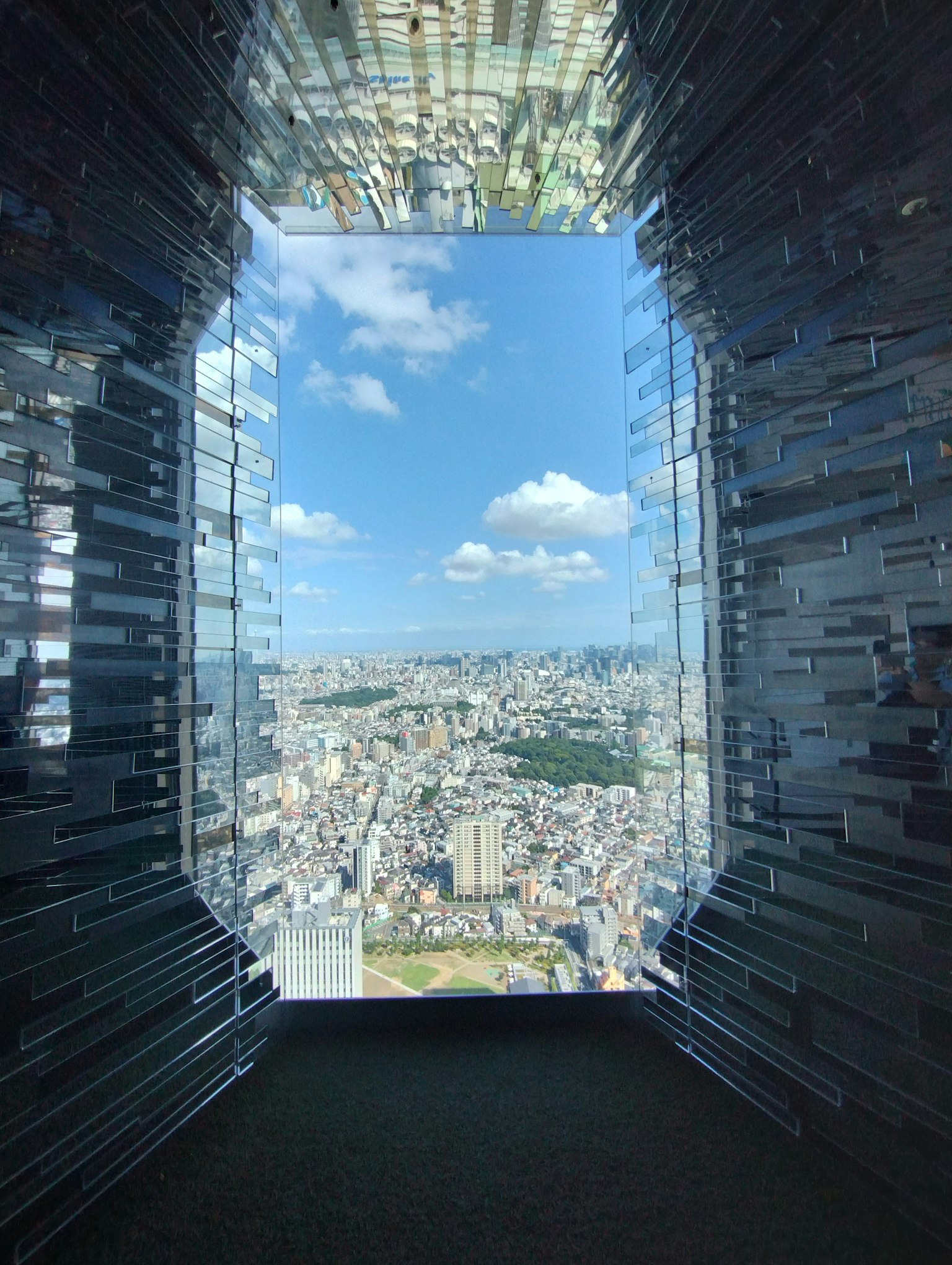 Cityscape view from a glass window bright blue sky and clouds