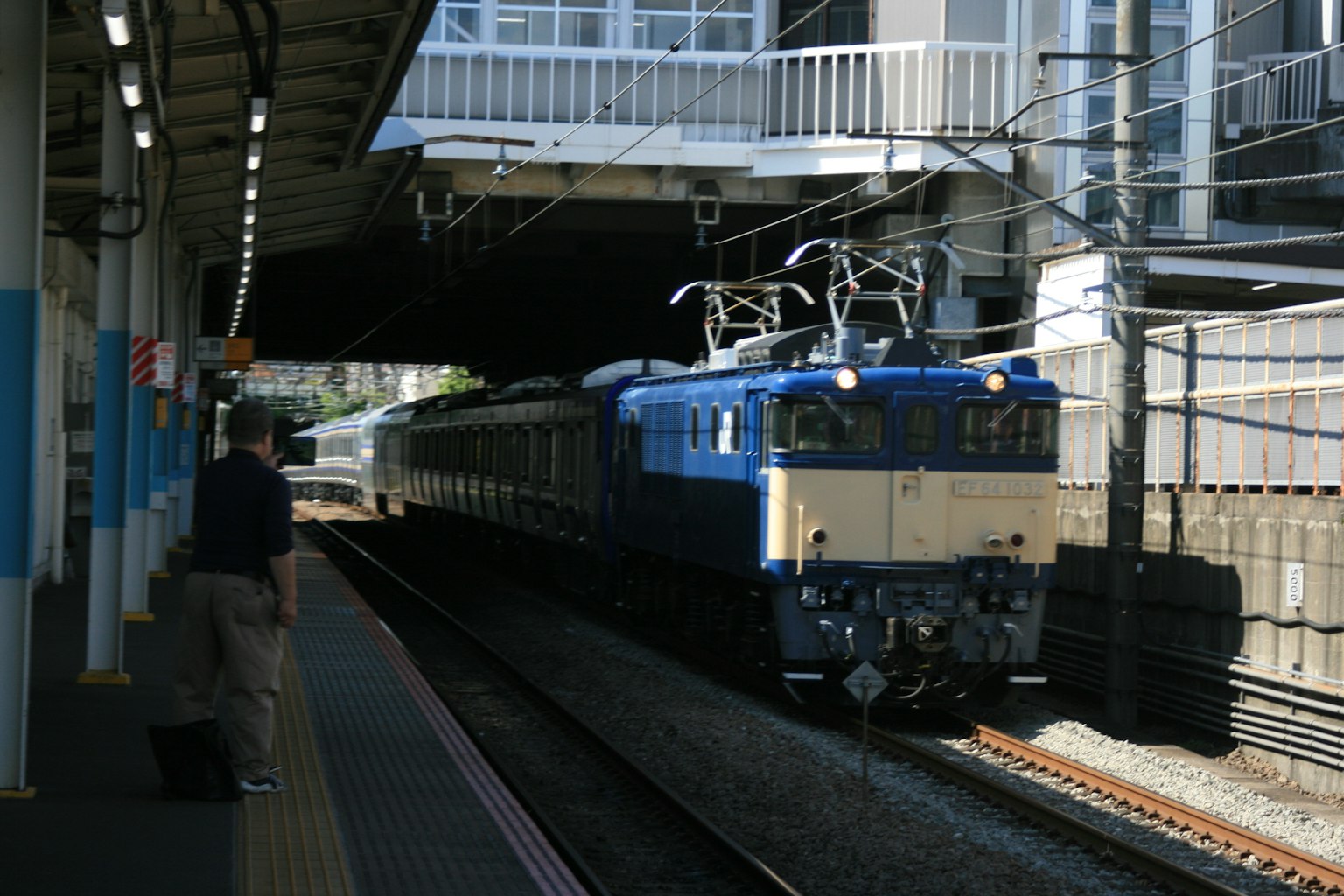 Train bleu arrivant à une gare