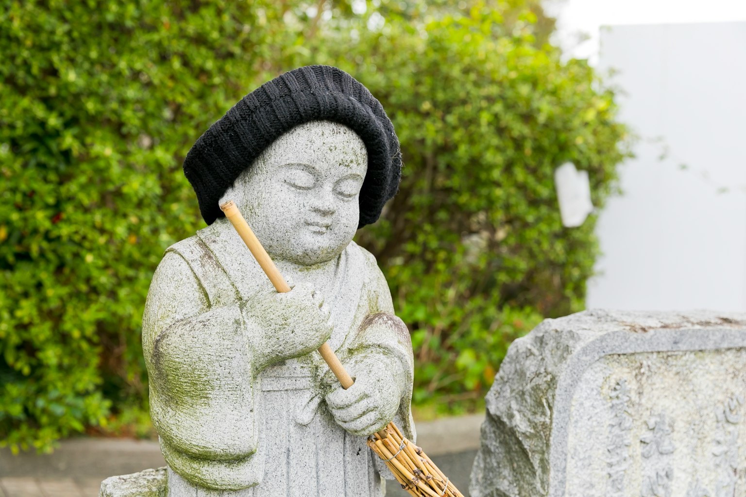 石雕儿童手持笛子戴着帽子