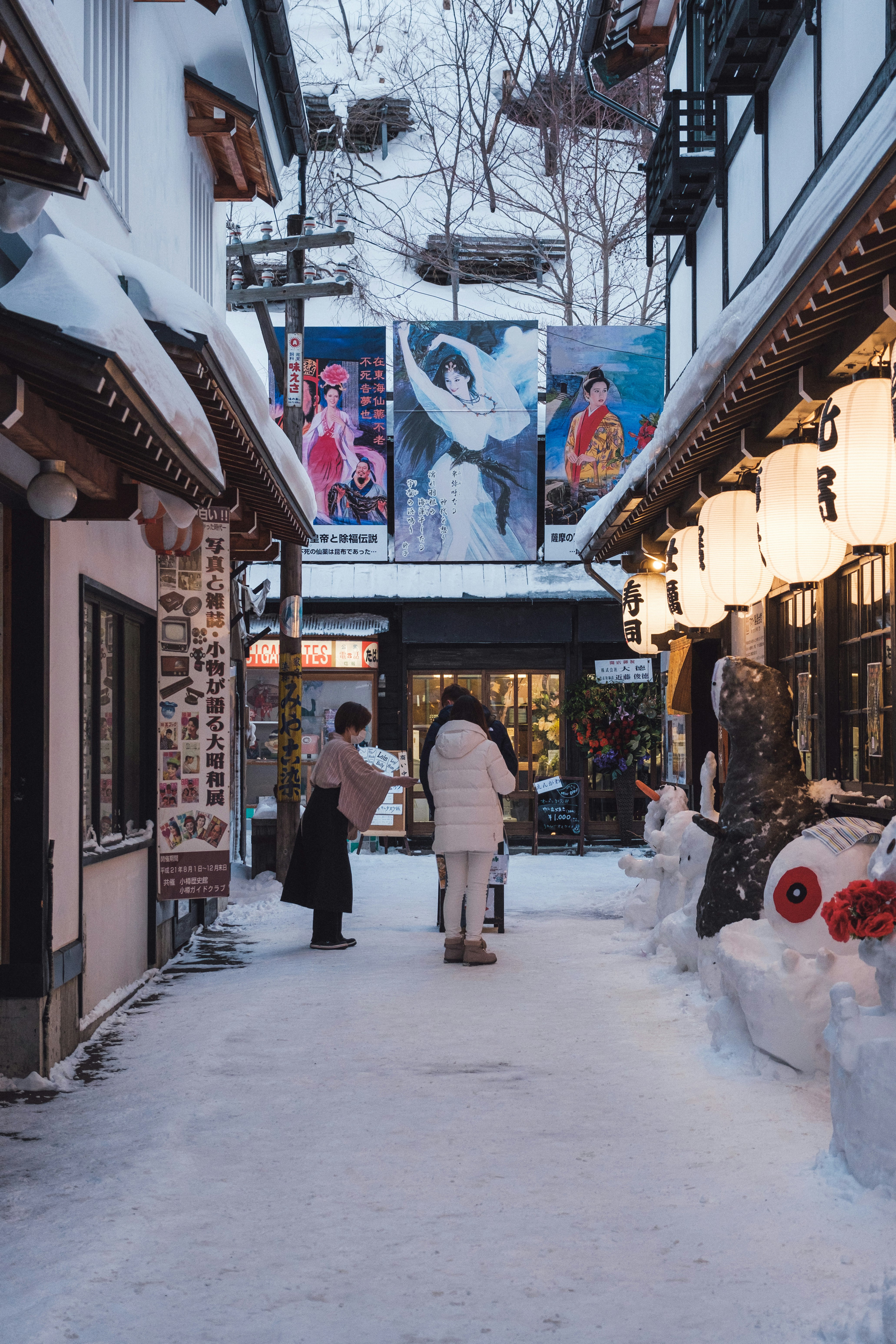 雪の降る路地の商店街の軒先と看板