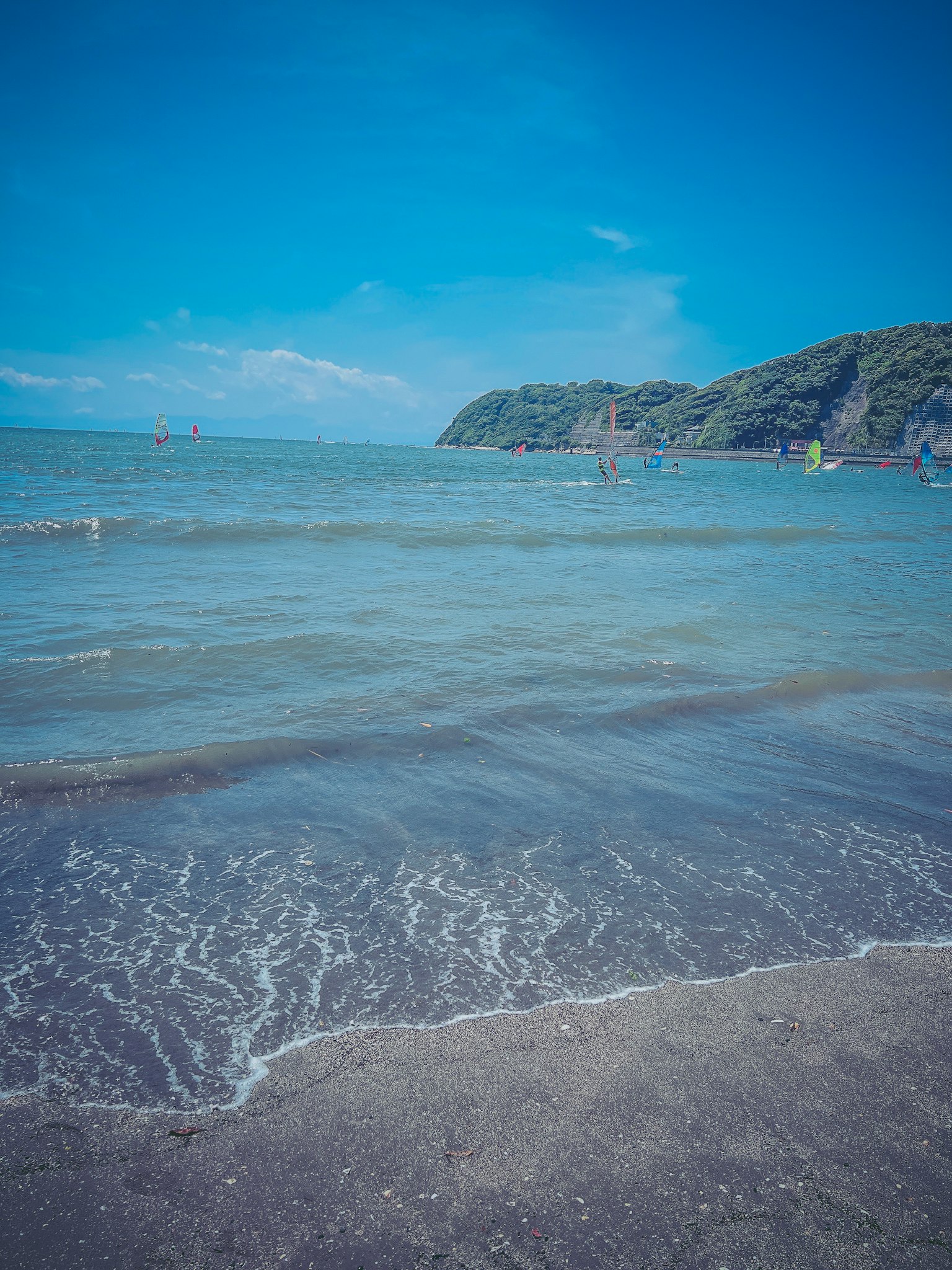 Pemandangan pantai dengan lautan biru dan ombak lembut