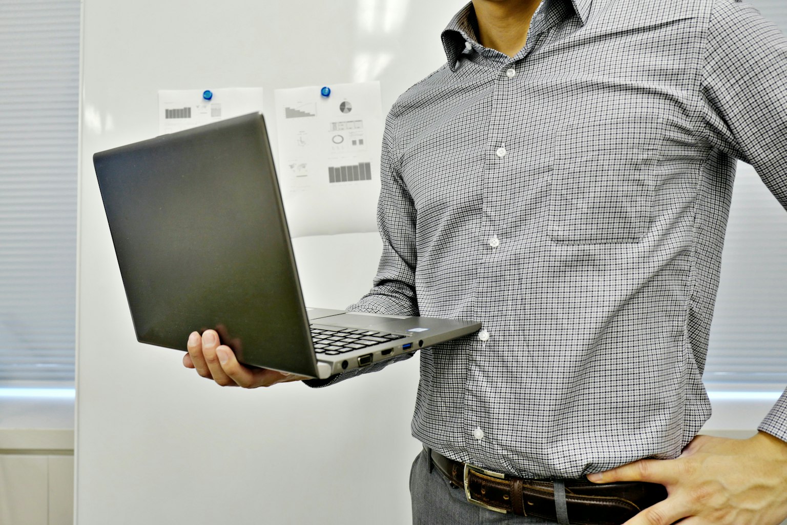 Pengusaha memegang laptop di lingkungan kantor