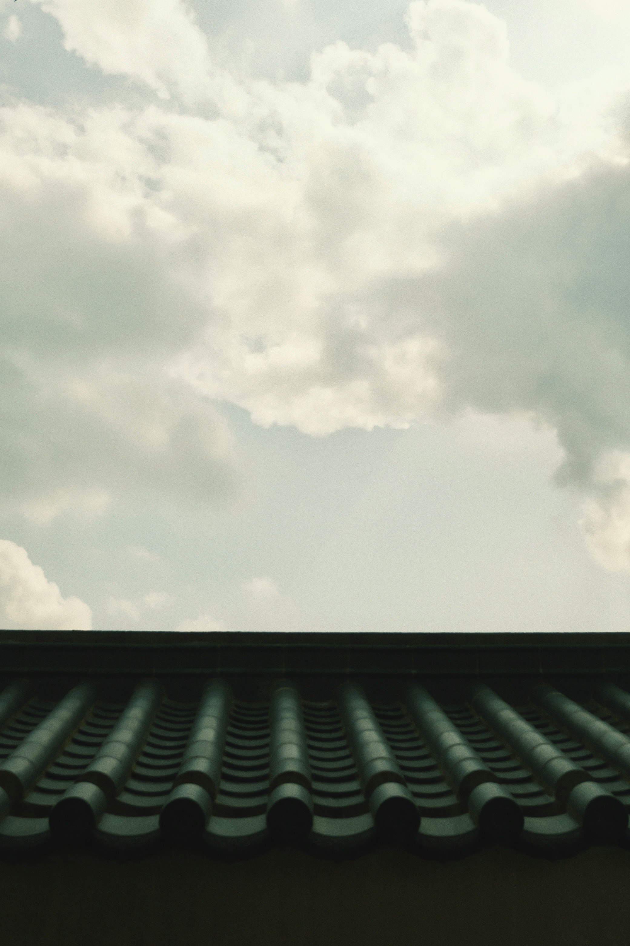 雲の広がる空と屋根の瓦