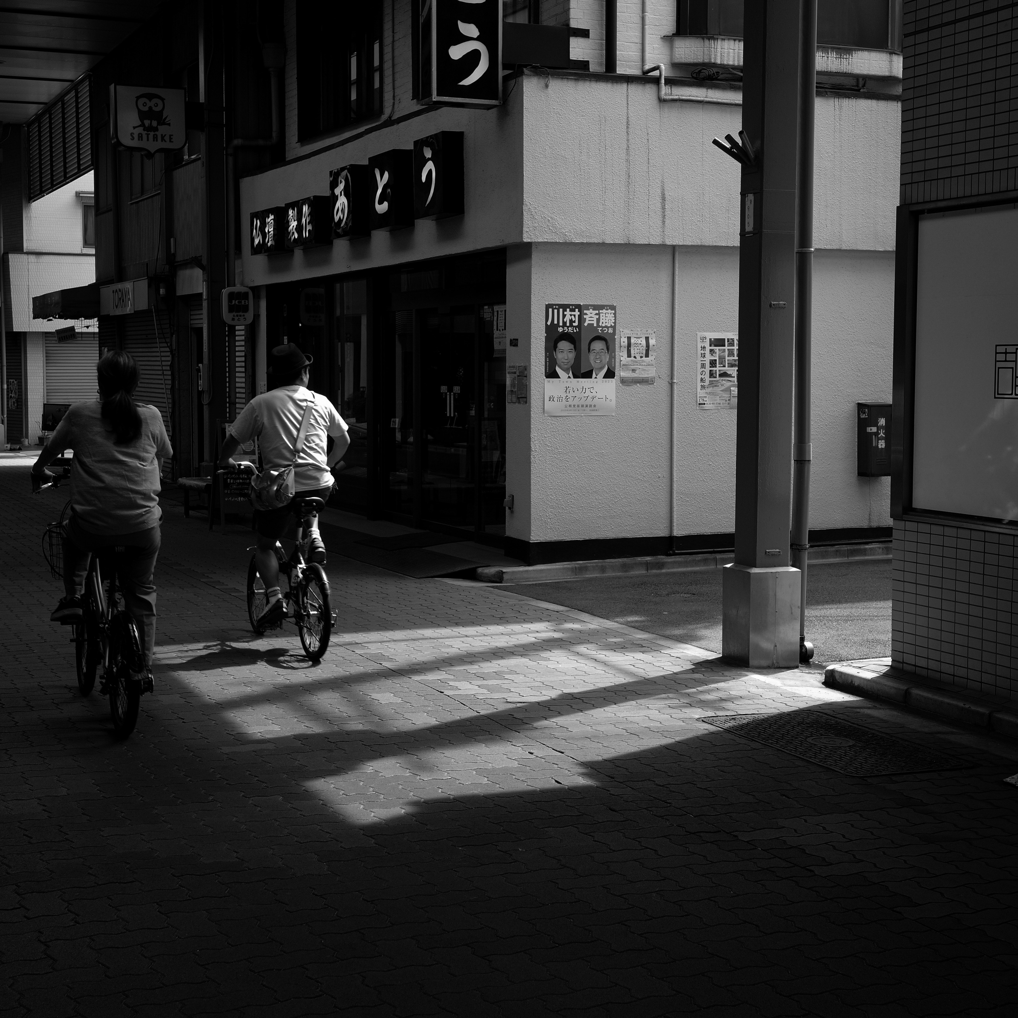 東京の路地にある商店街で自転車が並ぶアーケードの斜光