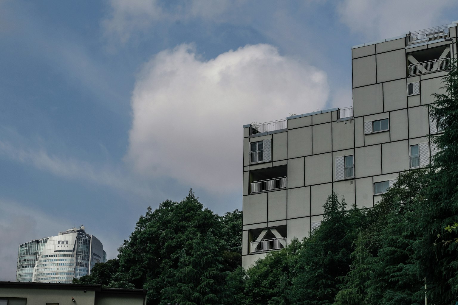 Bâtiment moderne entouré de verdure sous un ciel bleu