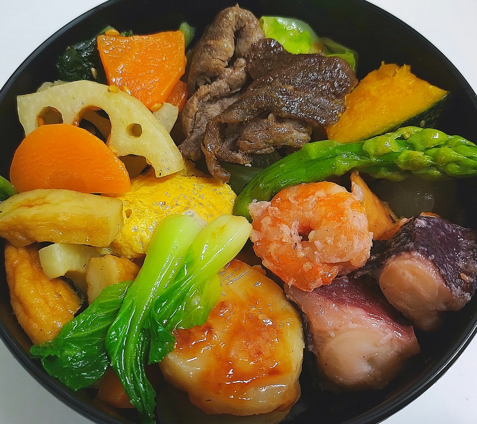 一個盛滿色彩繽紛的蔬菜和肉類菜餚的碗