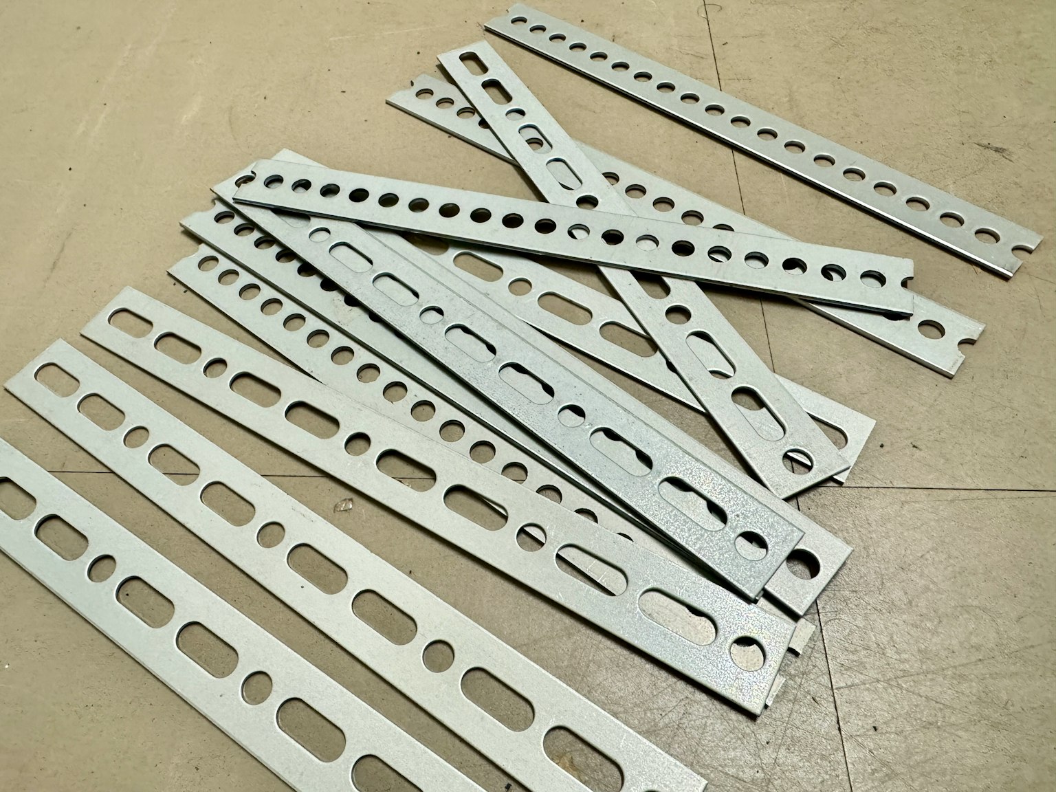 Strisce metalliche forate sparse su una superficie piana