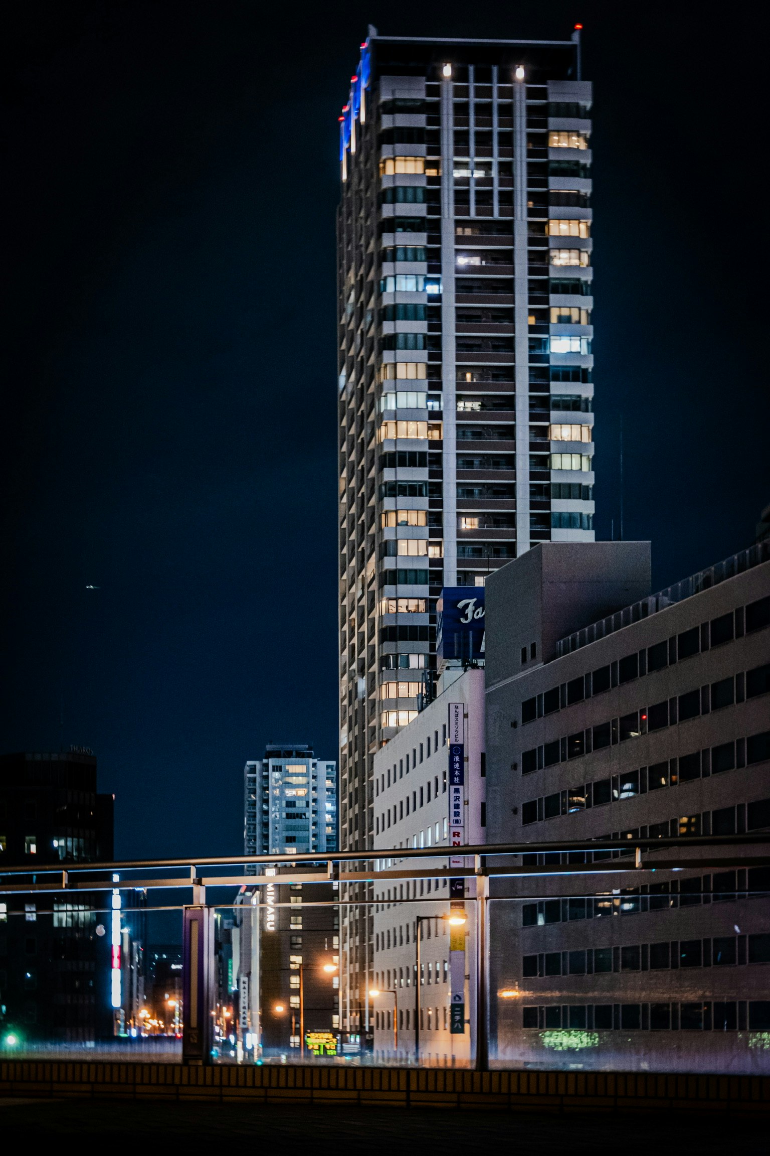 Paisaje urbano nocturno con un rascacielos iluminado