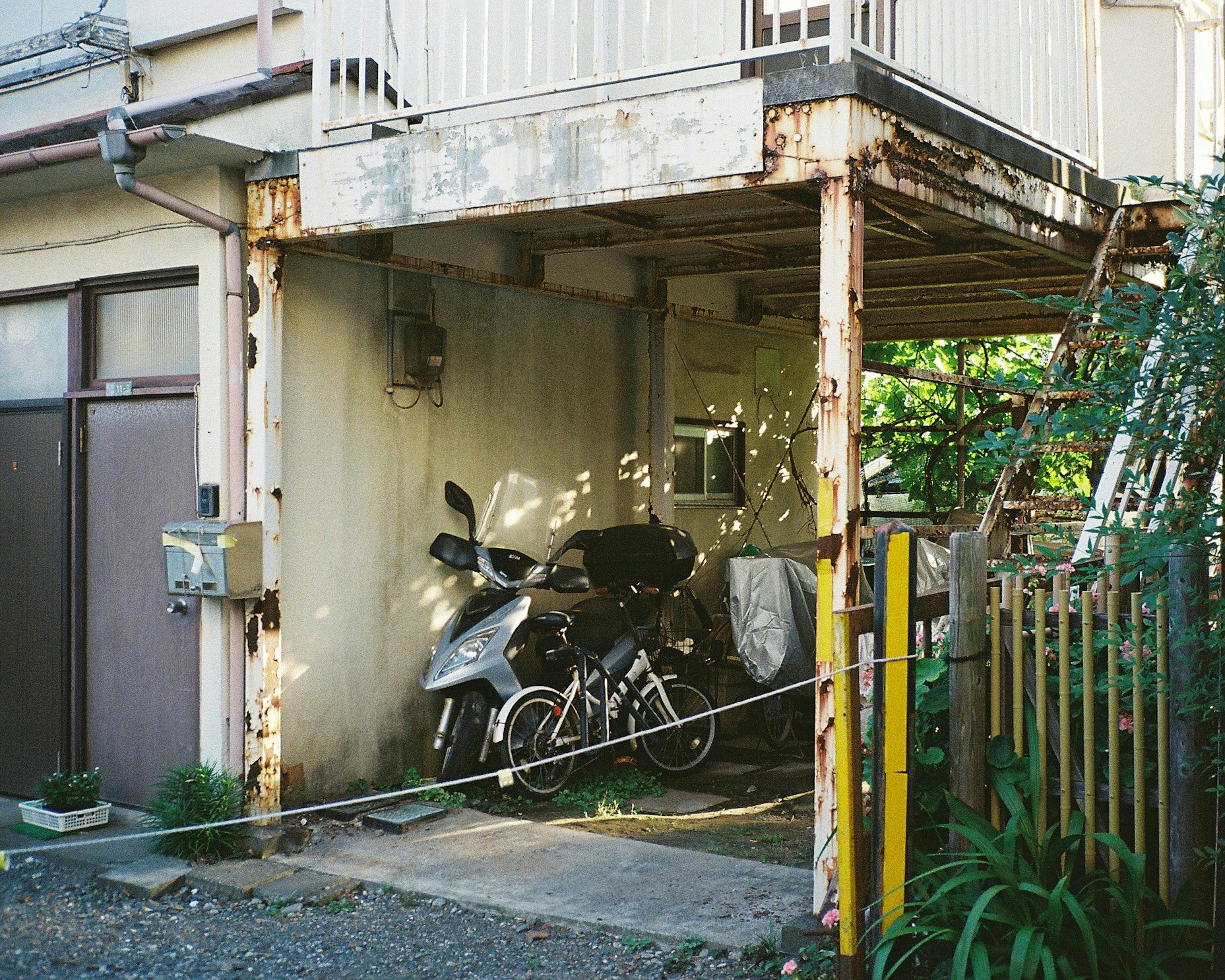 路地の物置小屋の軒下に置かれた自転車