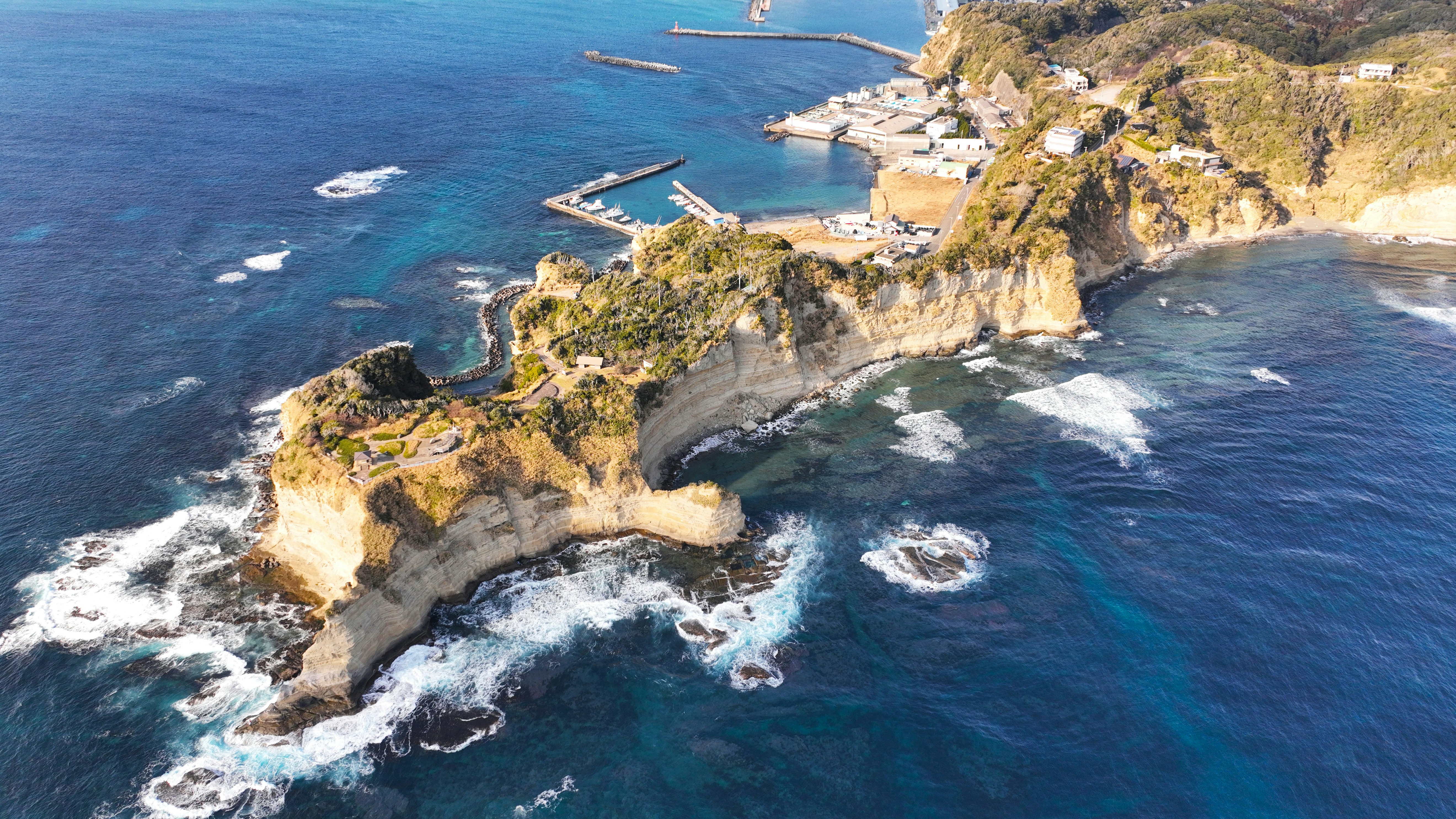 aerial view of a rugged coastline with cliffs and coves