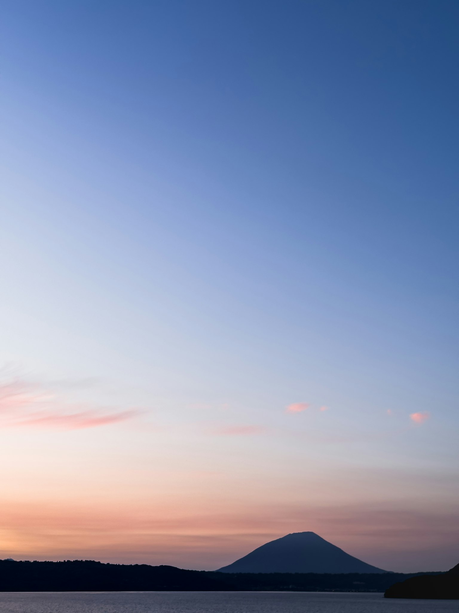 Cielo de atardecer tranquilo con silueta de montaña