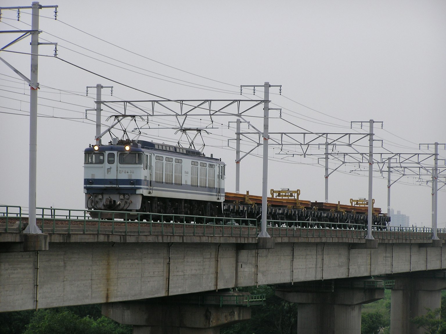 Tren cruzando un puente tirando varios vagones de carga