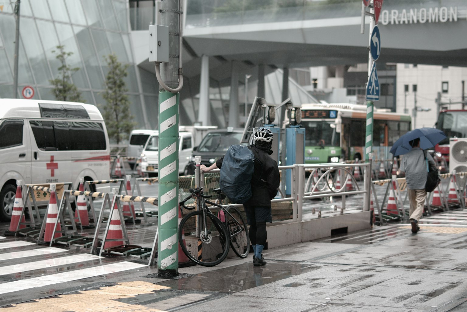 Scena urbana con persone che camminano sotto la pioggia e una bicicletta