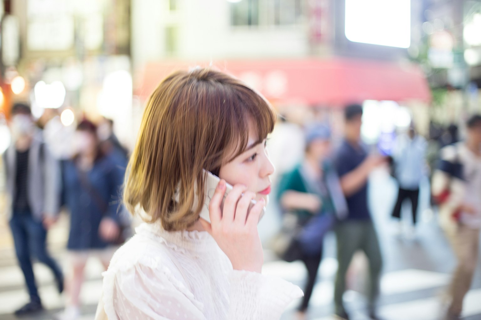 A woman talking on the phone in a busy urban setting